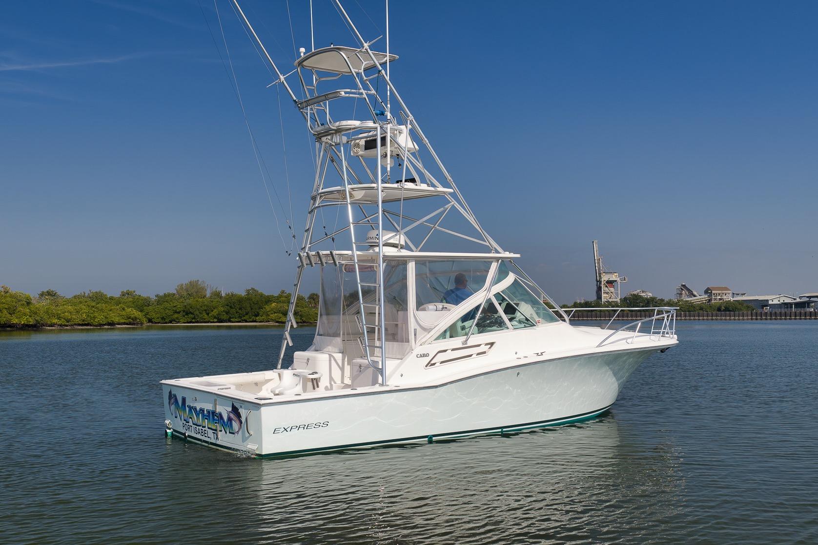 2006 Cabo 32 Express boat on calm water with clear blue sky.