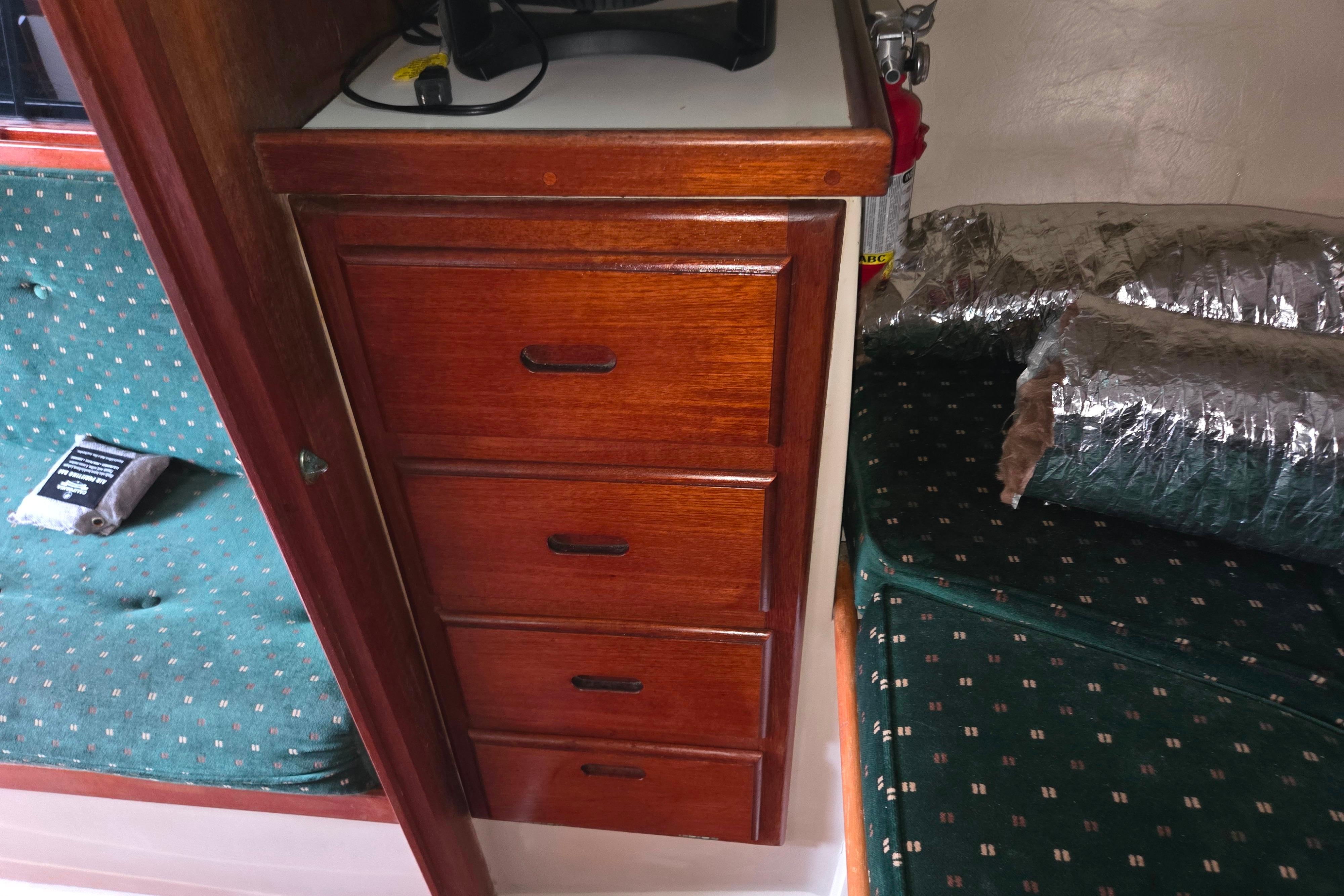 Wooden drawers and green upholstery inside a 1986 Catalina 355 boat cabin.