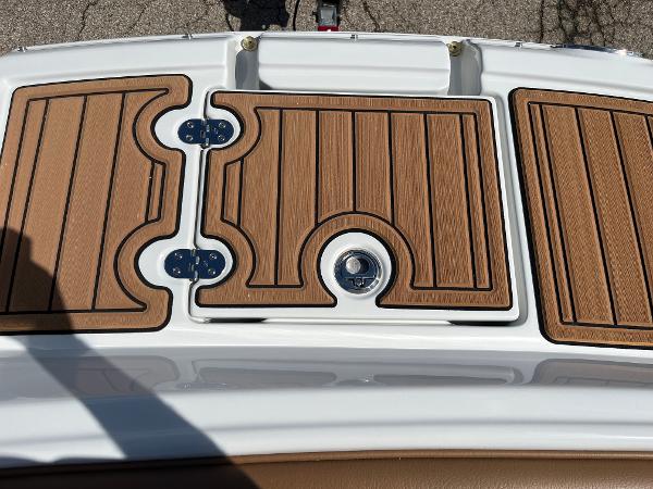 2024 Crownline Eclipse E255 boat deck with wood finish and metal hinges.