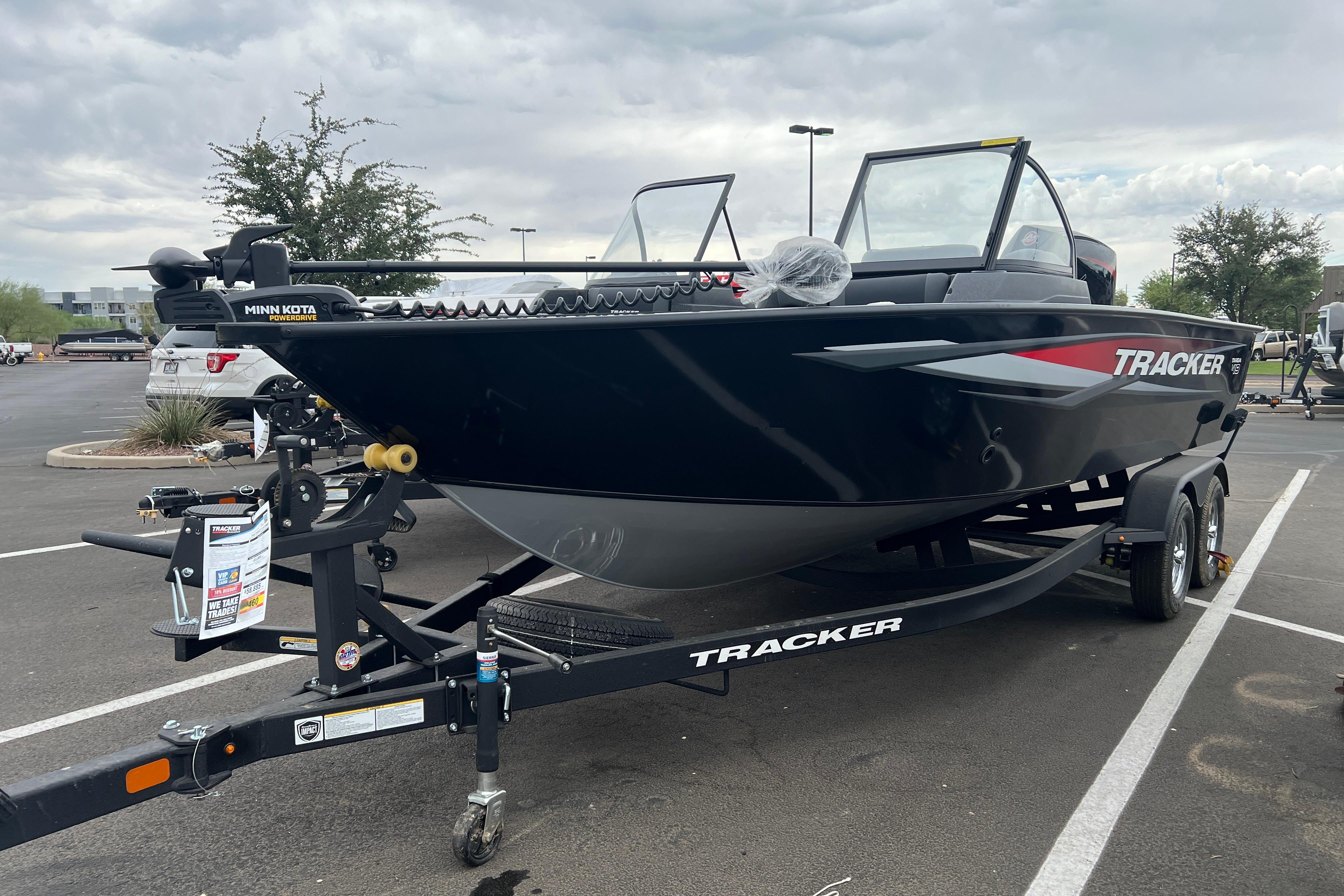 2026 Tracker Targa V-19 Combo boat on trailer in parking lot, overcast sky.