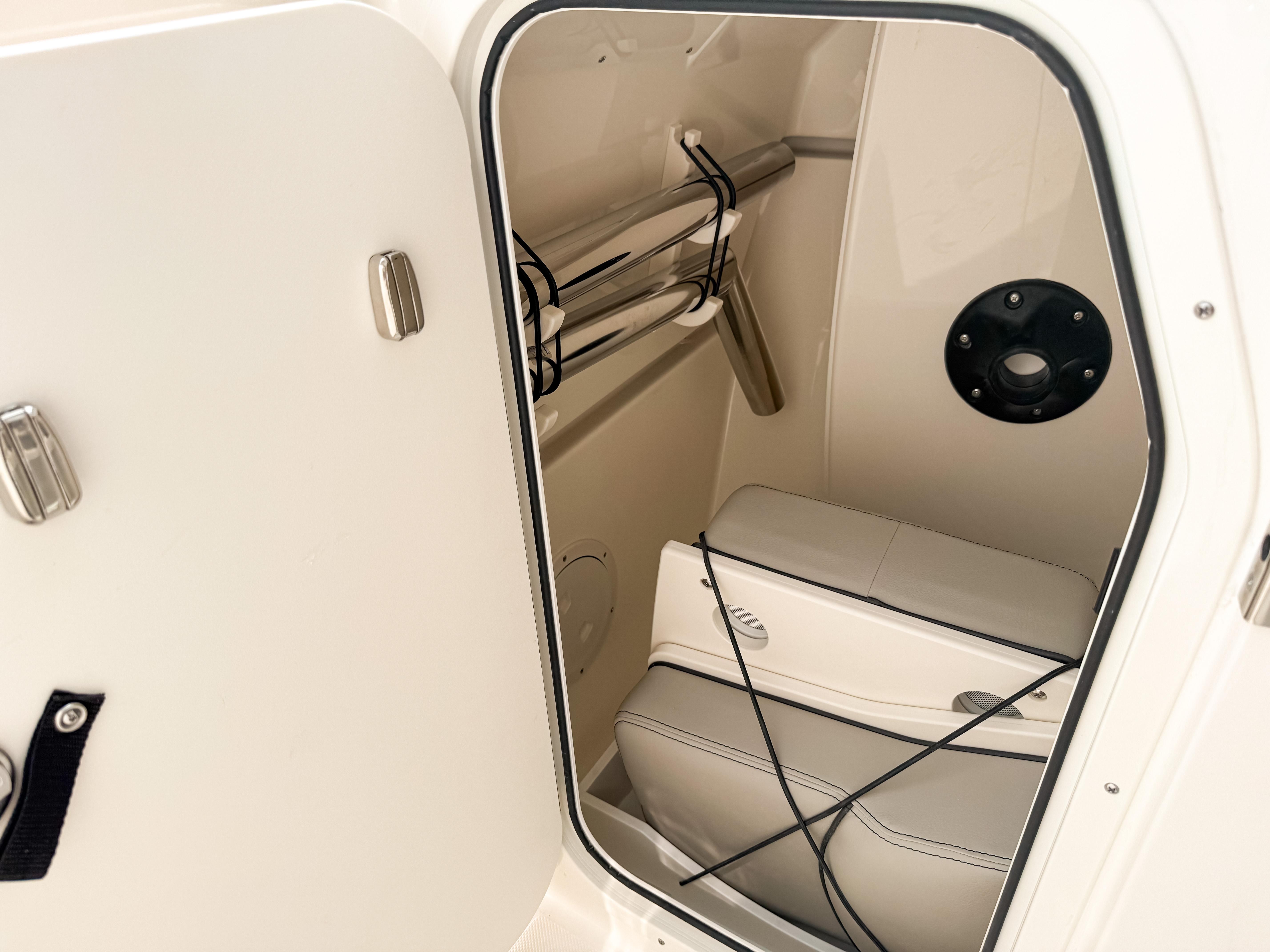 2025 Pursuit DC 266 Dual Console interior storage compartment with seating and metal fixtures.