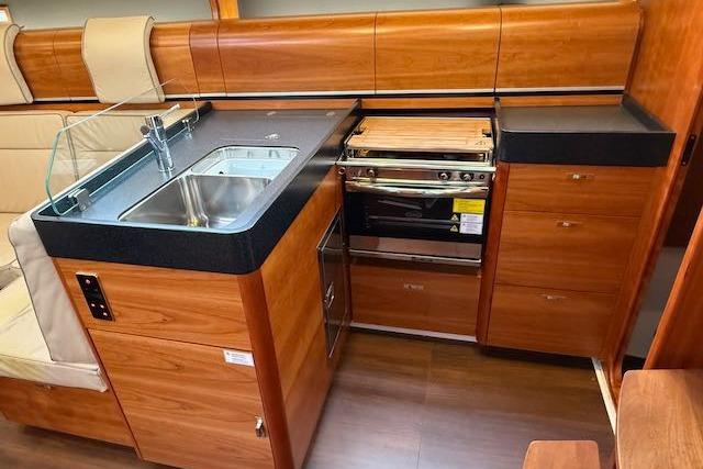 2017 Dehler 38 yacht interior kitchen with wooden cabinetry and modern appliances.