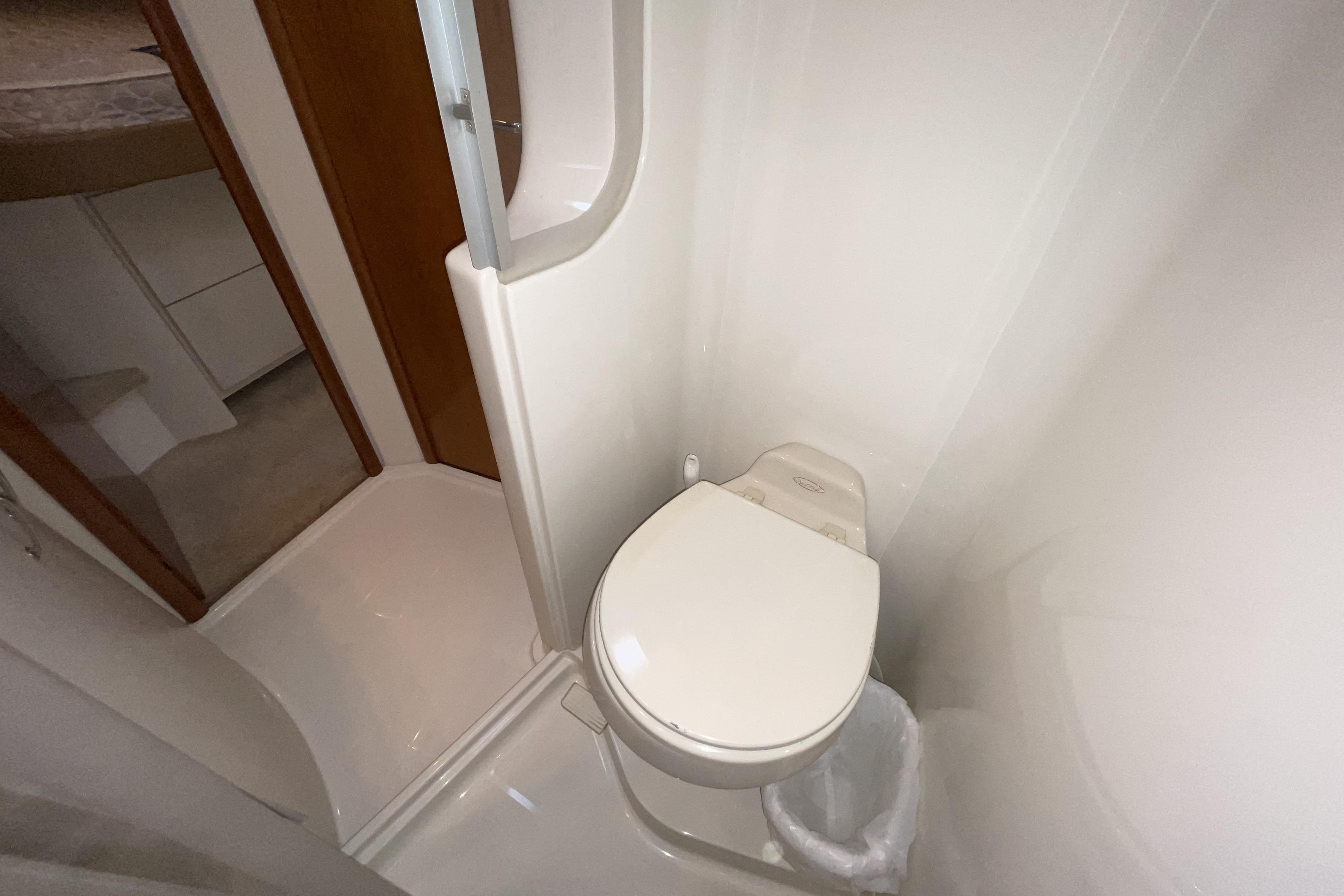 Bathroom interior of 2005 Carver 38 Super Sport yacht, featuring compact toilet and shower.