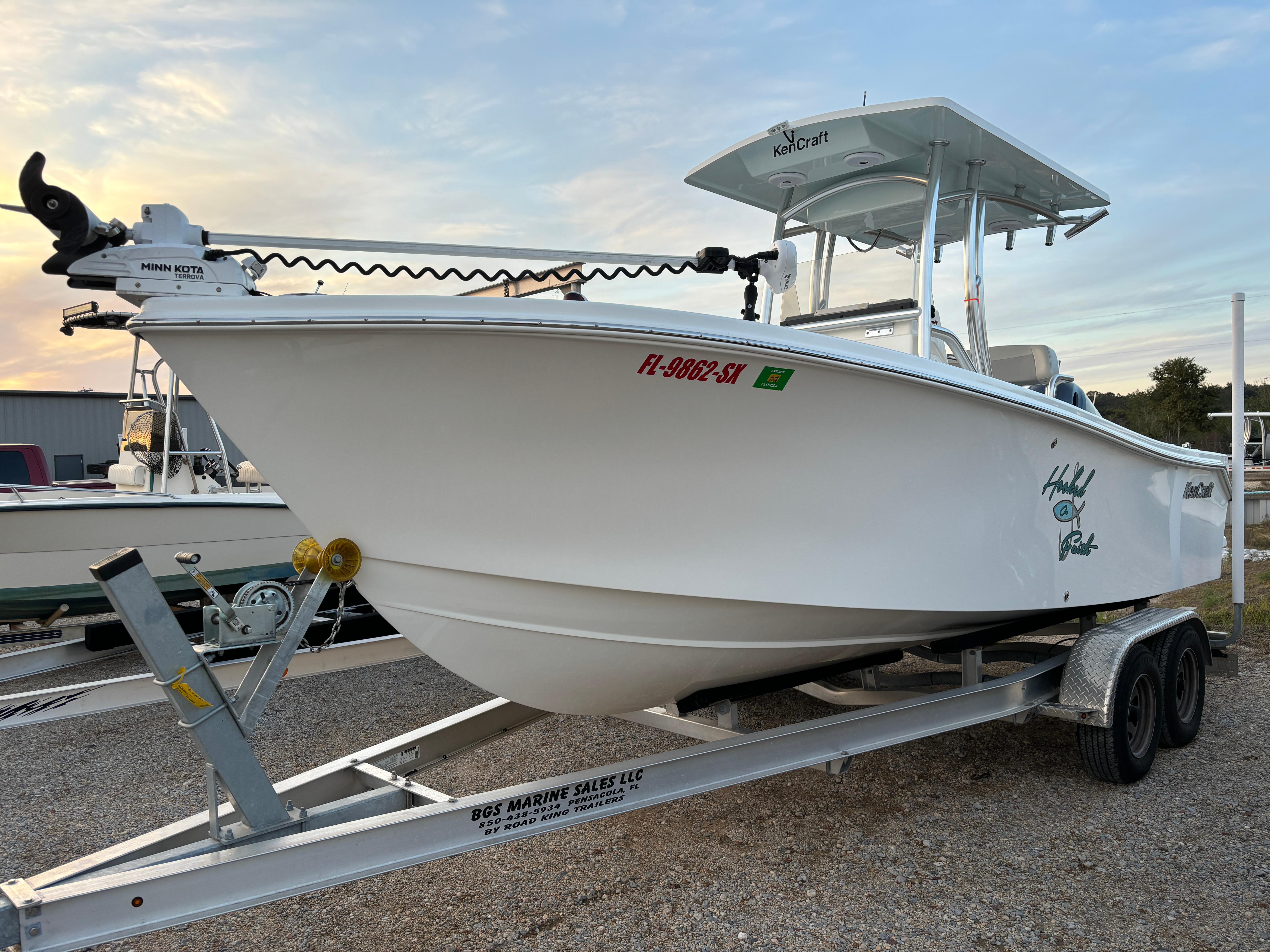 2021 KenCraft 21 boat on trailer, white hull, parked outdoors.
