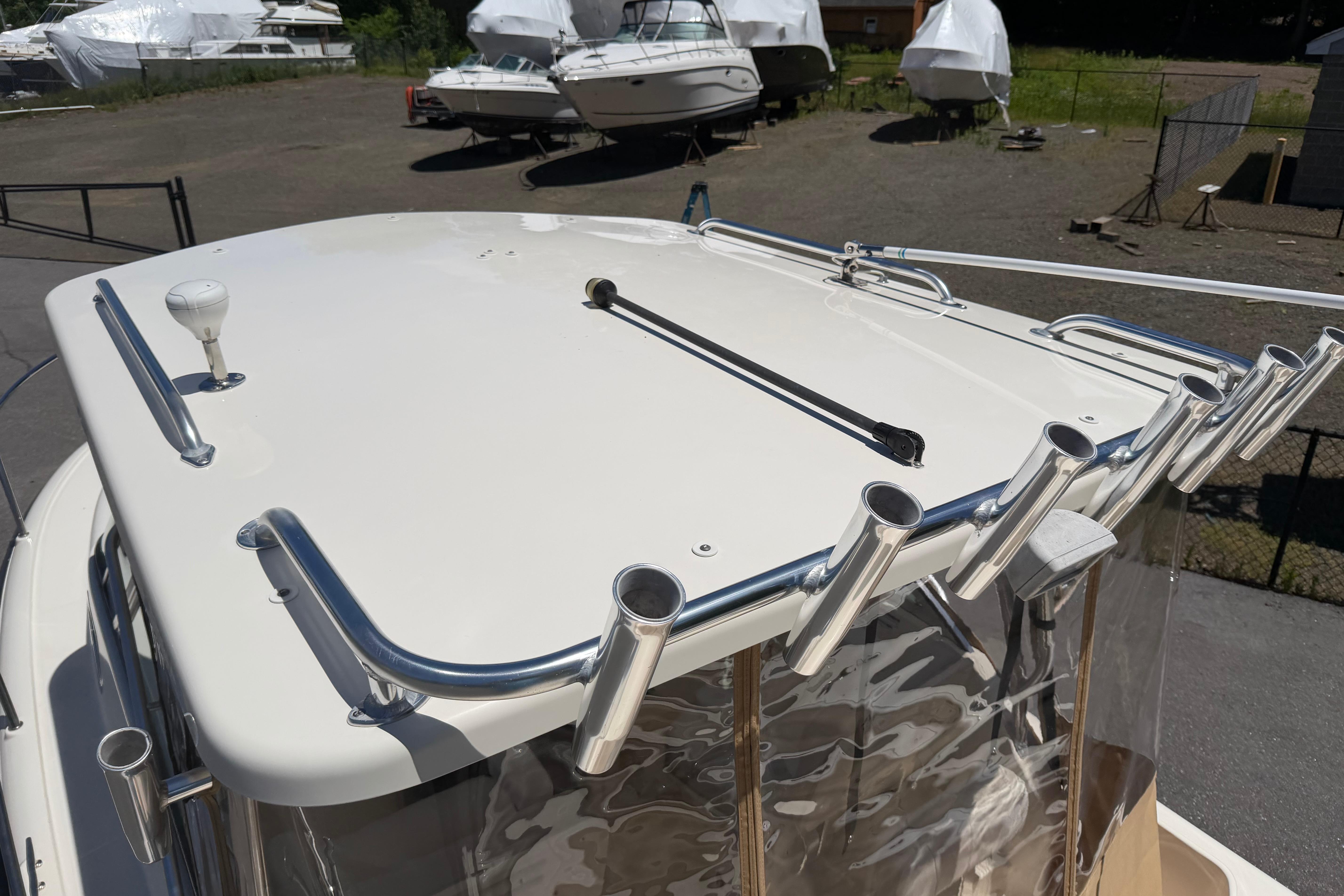 2010 Pursuit OS 255 Offshore boat roof with rod holders in a marina.