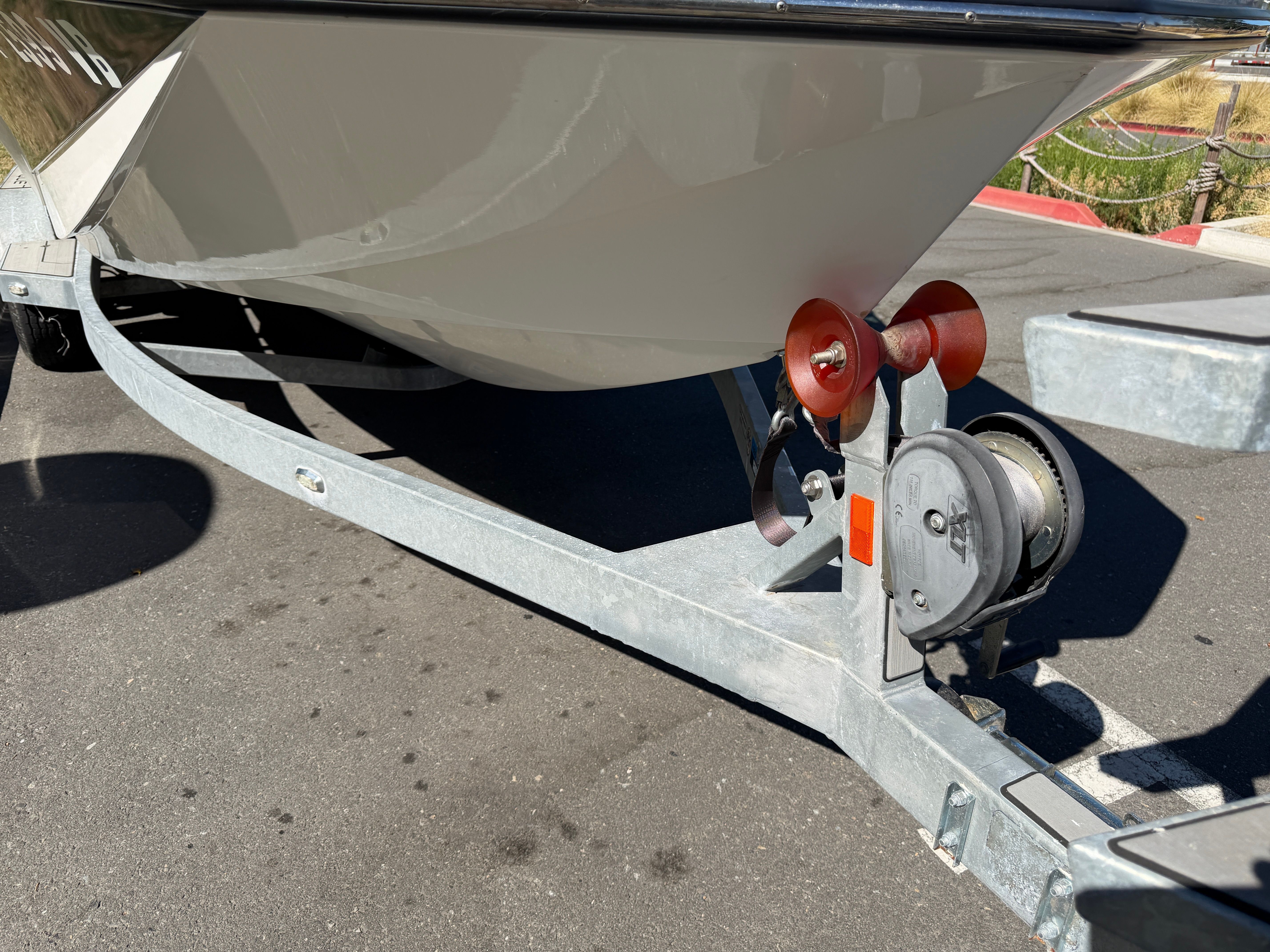 The bow of a boat on a trailer with a winch and rollers.