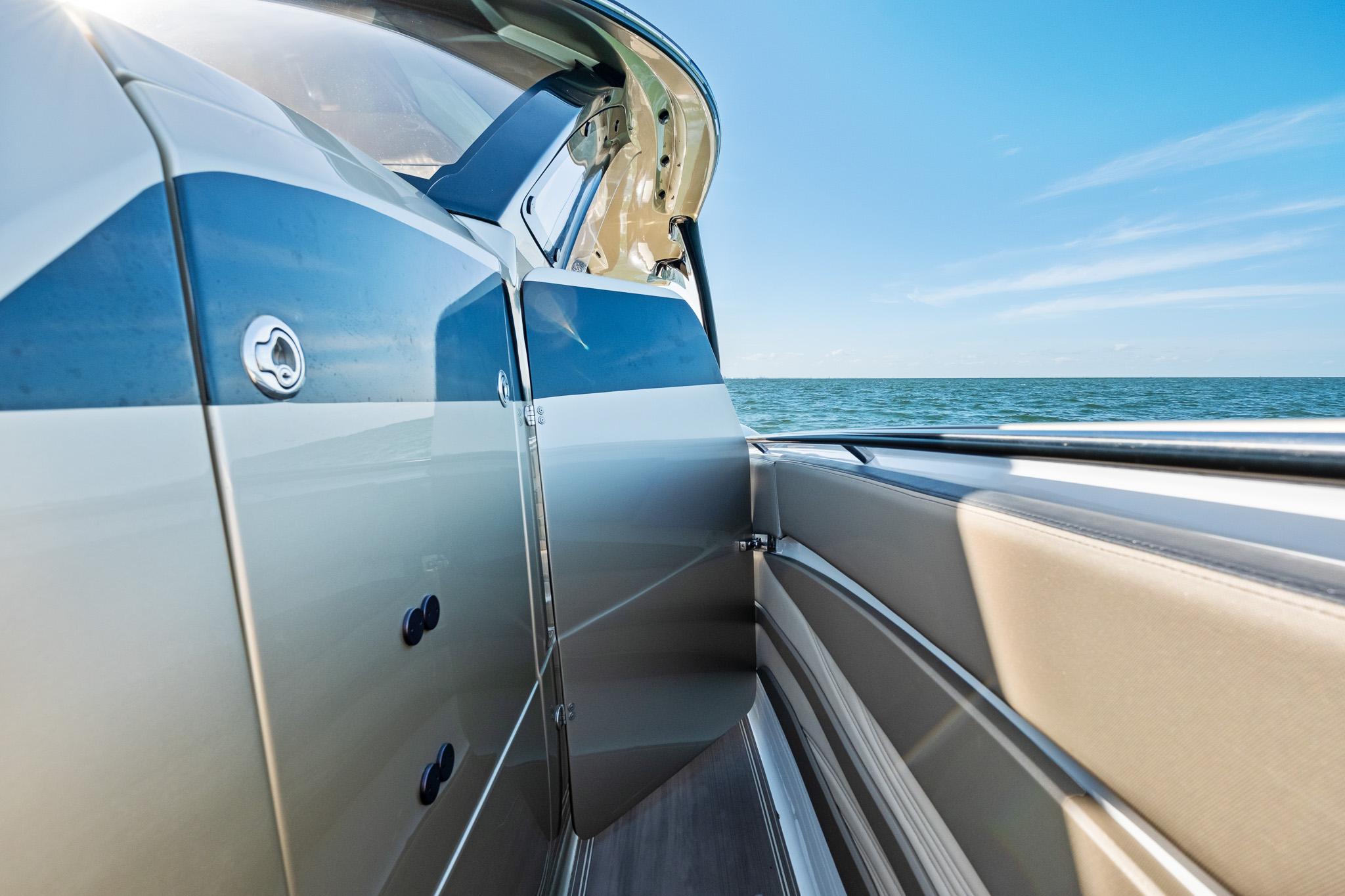 2021 MTI V42 boat side view with ocean backdrop and clear blue sky.