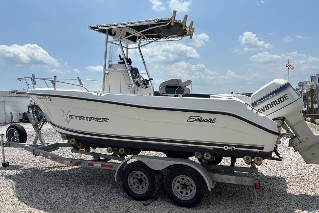 2002 Seaswirl Striper 2101 Center Console boat on trailer, featuring Evinrude outboard motor.