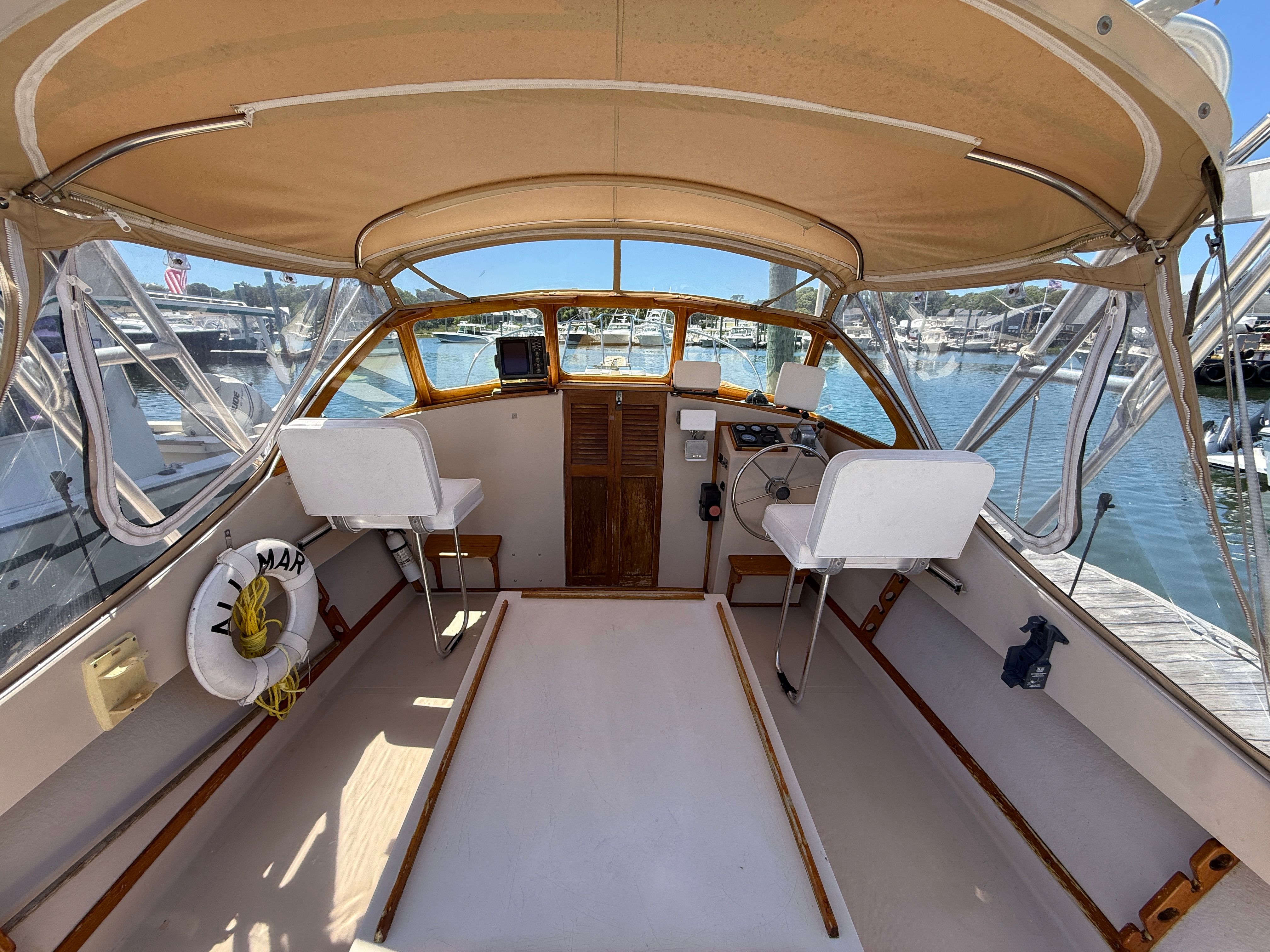 The cockpit of a 1989 Fortier 26 boat docked at a marina.