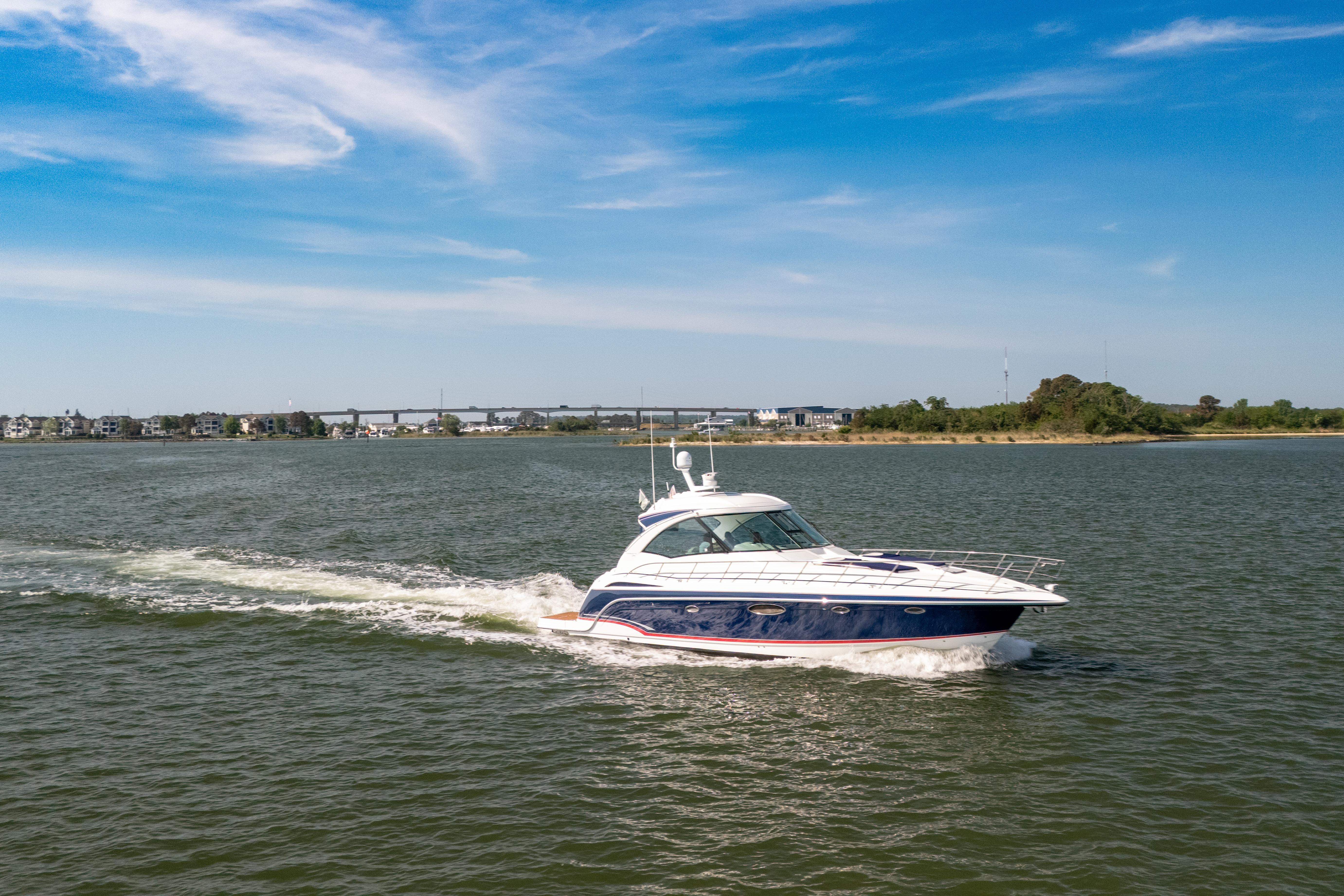 2010 Formula 45 Yacht cruising on a sunny day with scenic shoreline backdrop.