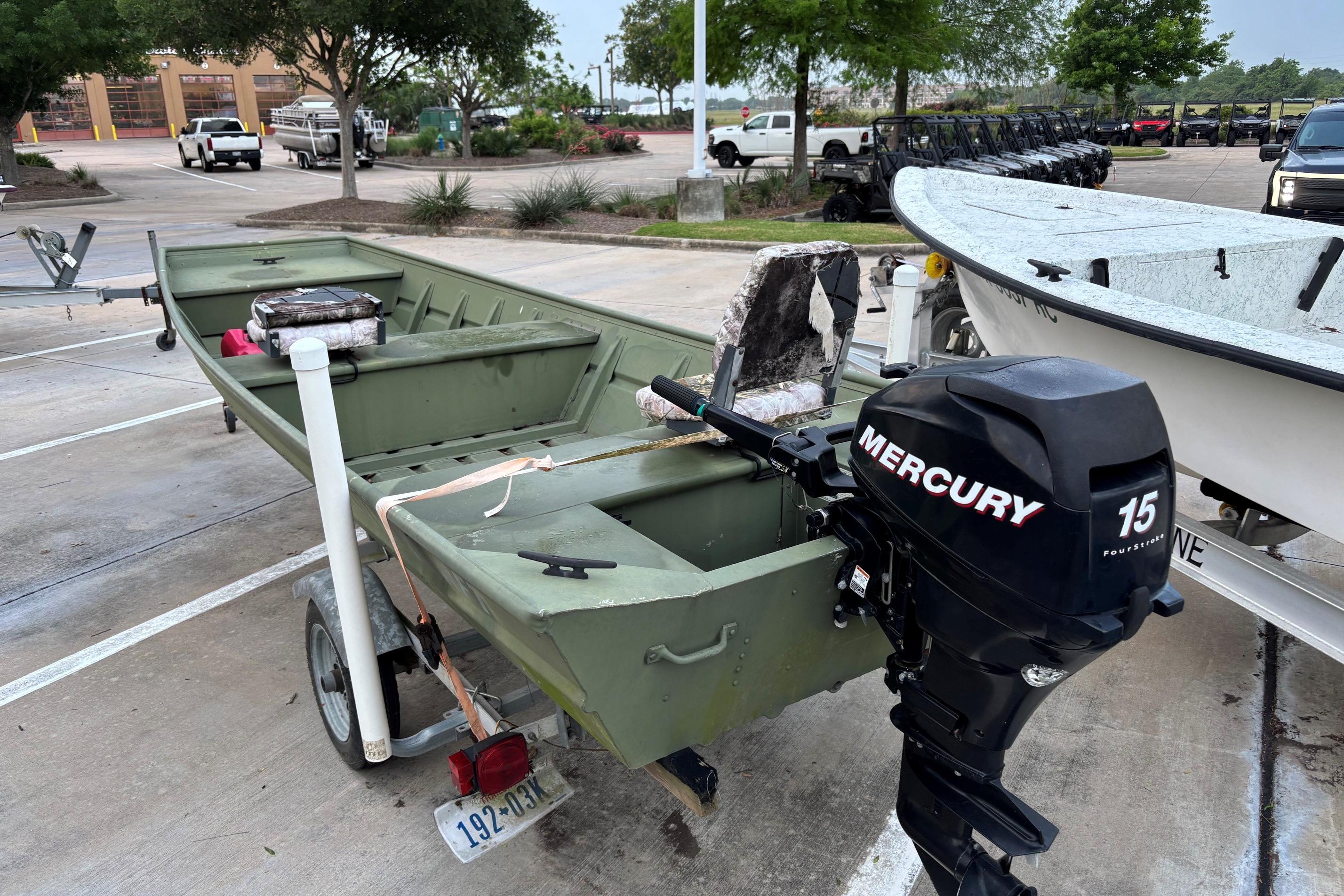 2011 Alumacraft 1542 Jon boat with Mercury 15 outboard motor in parking lot.