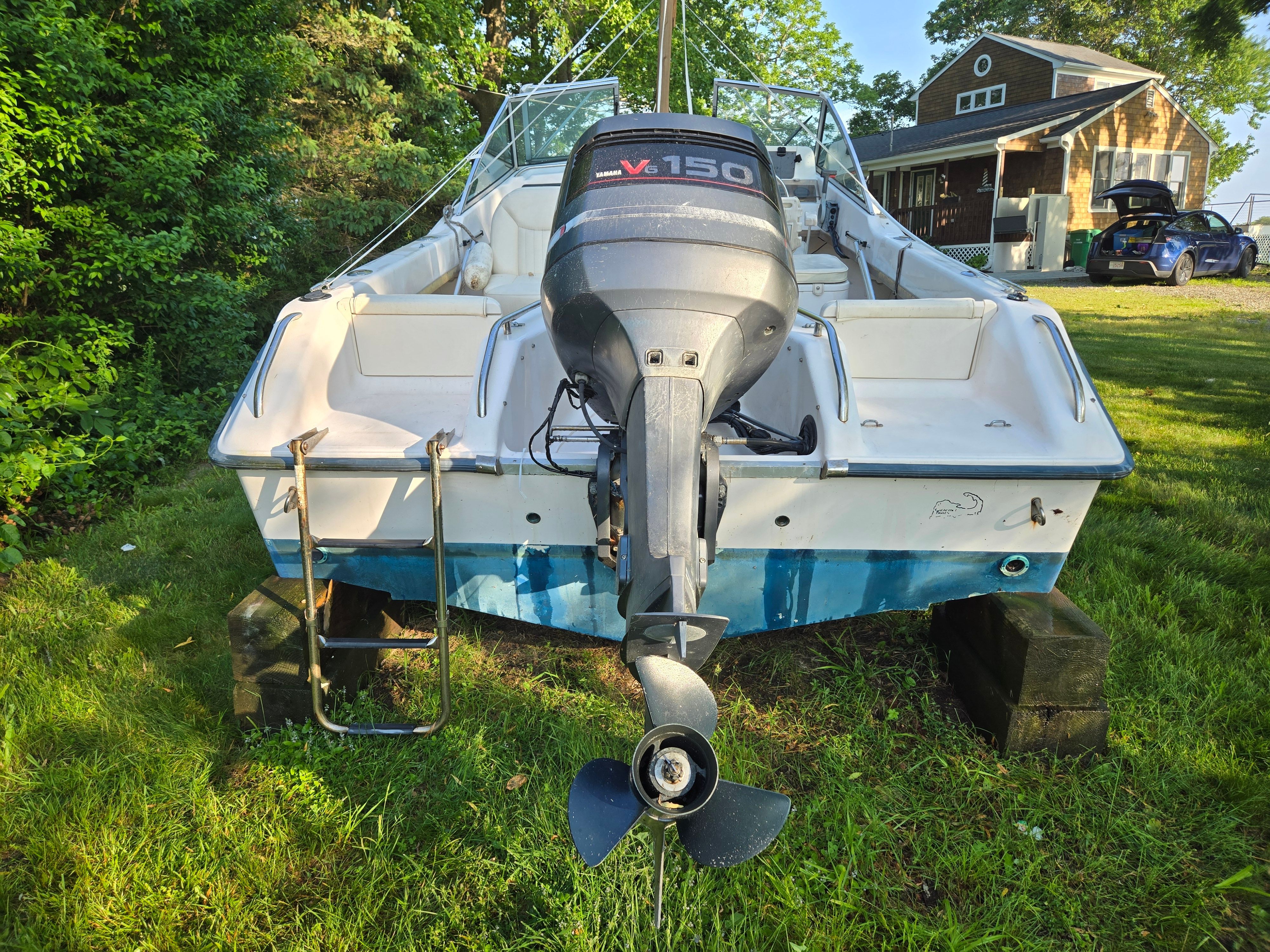 A 1994 Grady-White Tournament 192 boat on grass with an outboard motor.