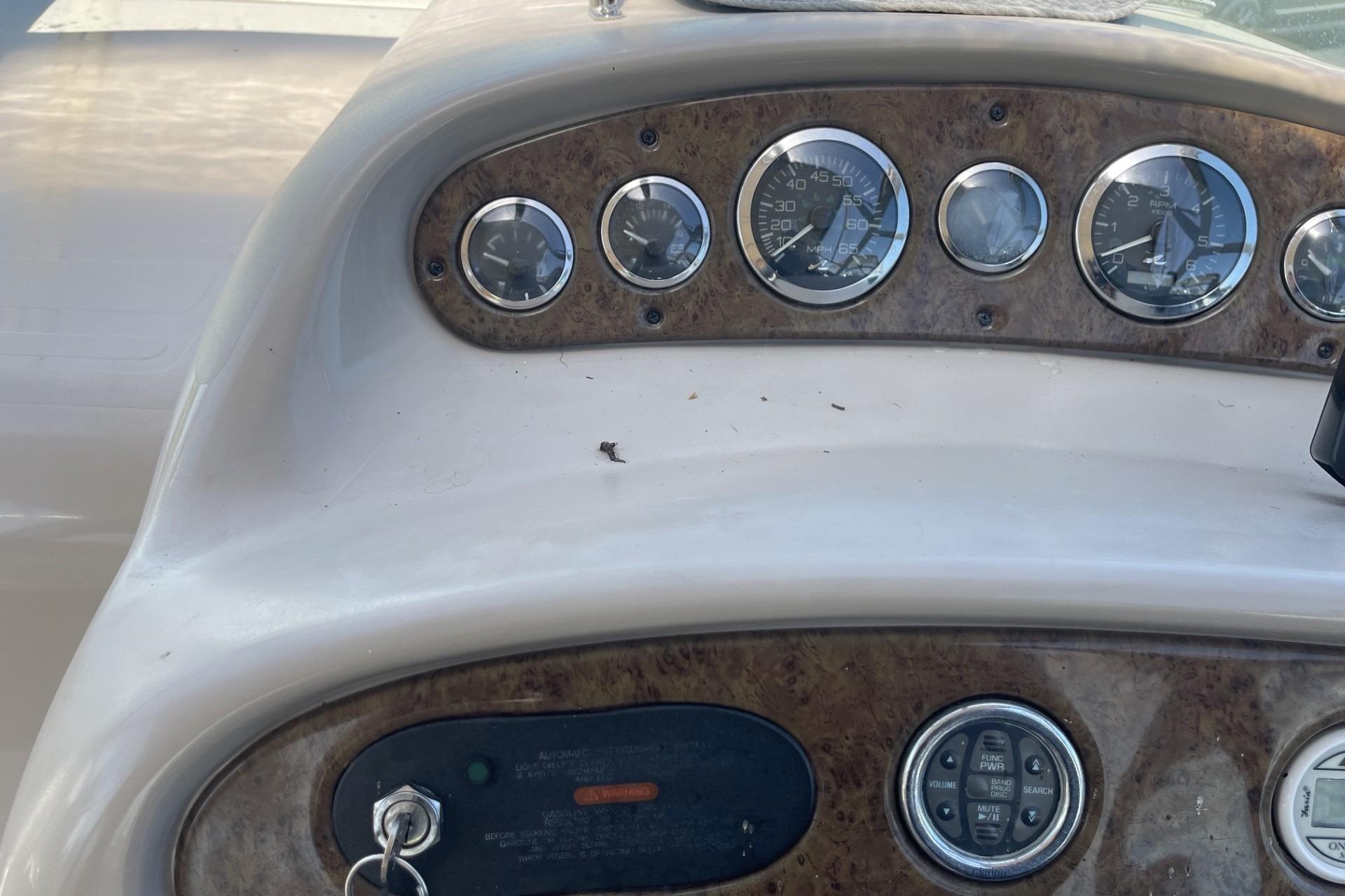 Dashboard of a 2000 Sea Ray Sundancer 260 boat with gauges and controls.