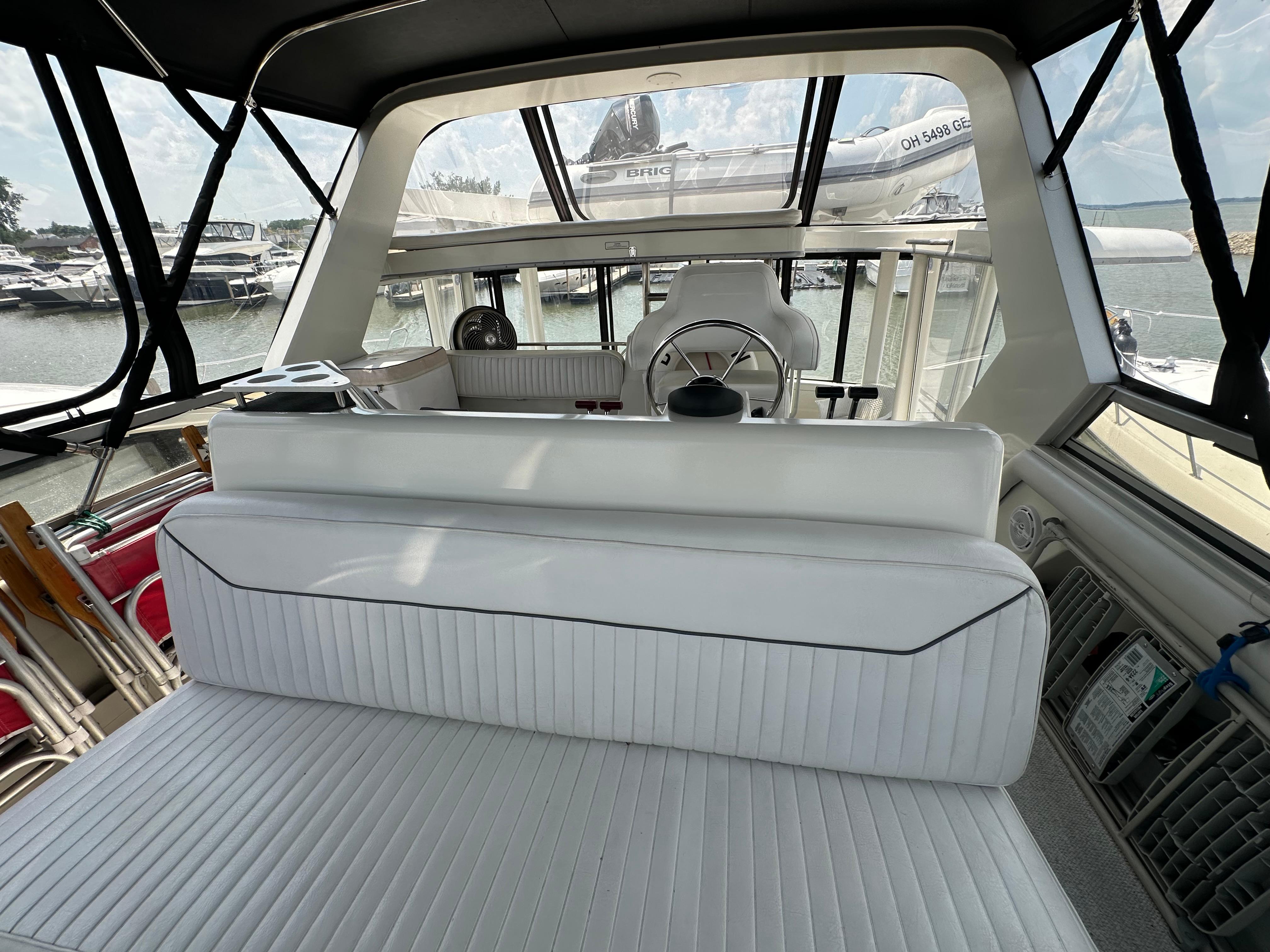 1995 Carver 440 Aft Cabin Motor Yacht interior with white seating and helm view.
