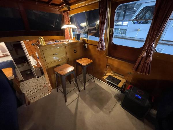 Interior of a 1951 Chris-Craft Catalina boat with wooden decor and bar stools.