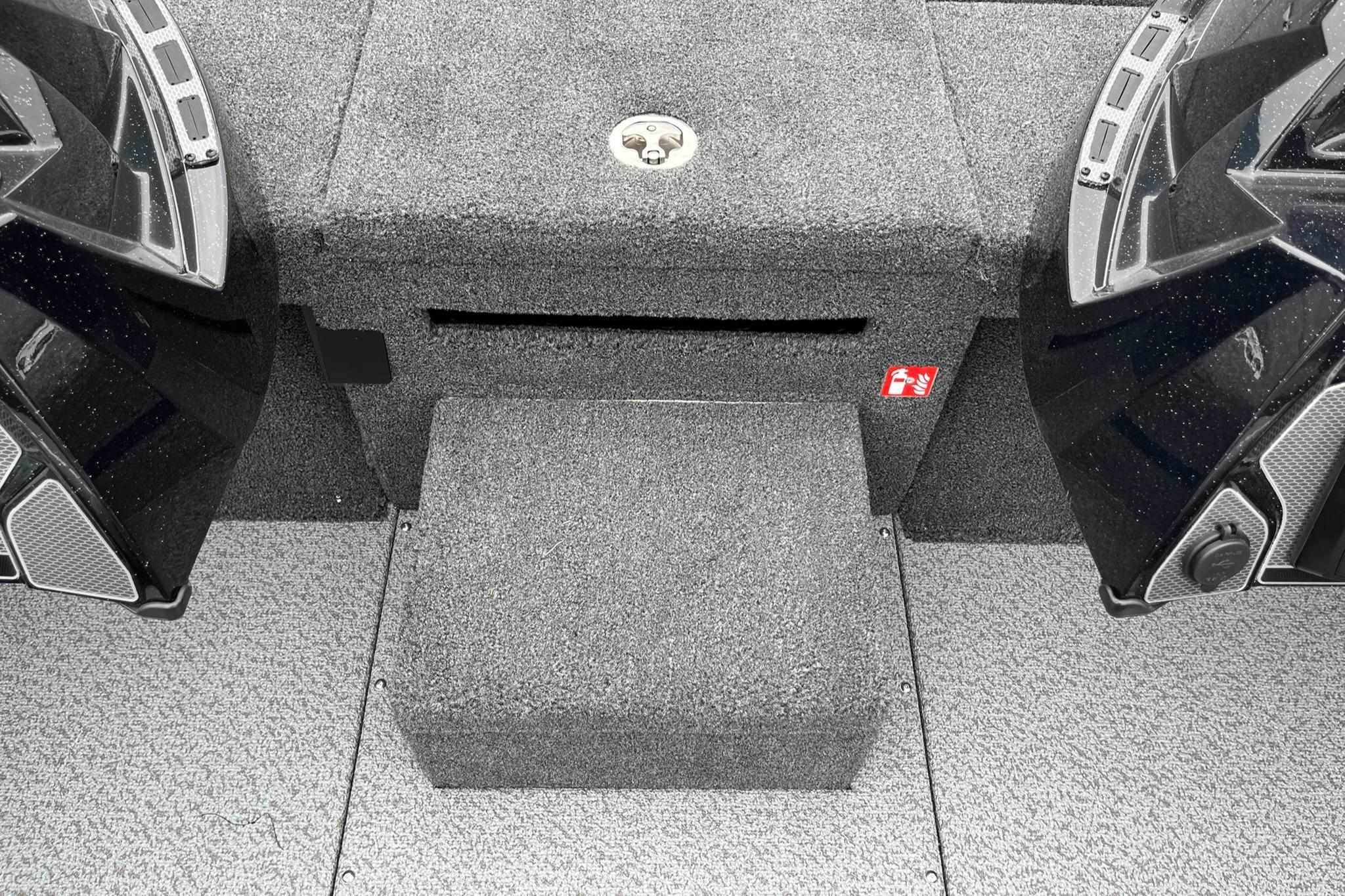 2026 Lund 1875 Pro-V Bass XS boat interior with carpeted flooring and storage compartments.