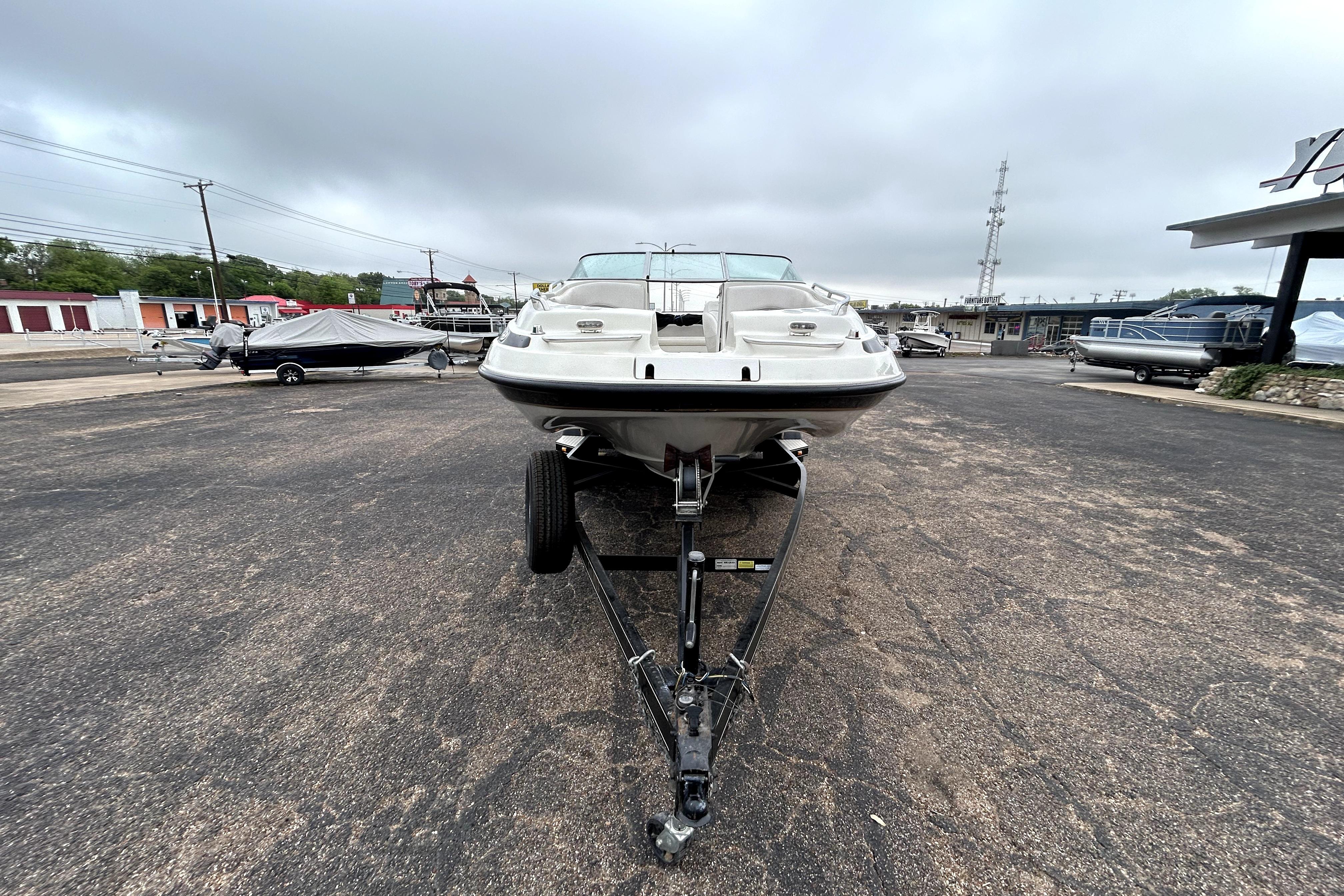 2001 Crownline 239 DB boat on trailer in parking lot, overcast sky.