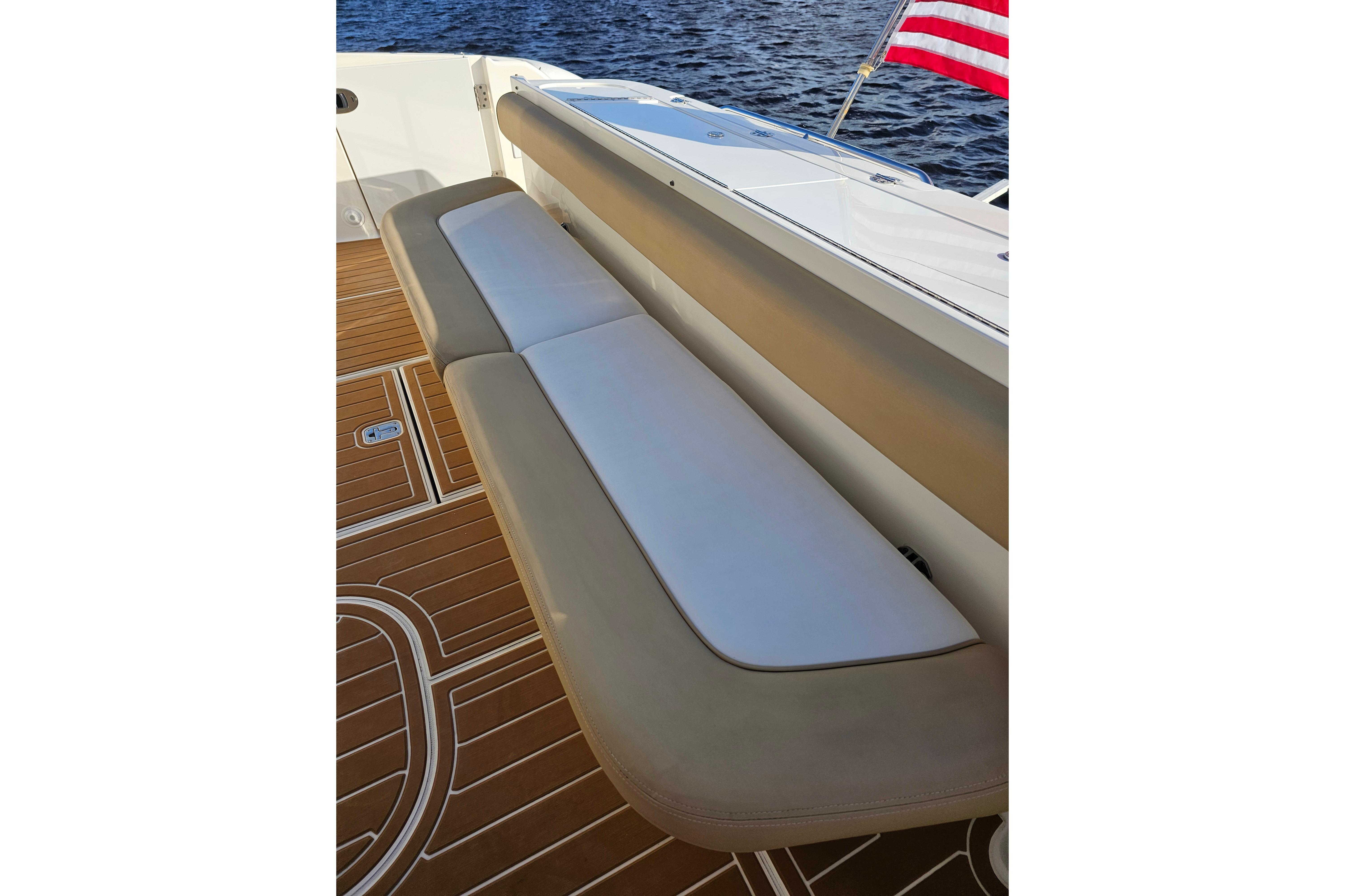Luxury seating on 2006 Sea Ray 580 Sedan Bridge yacht, with teak deck and American flag.