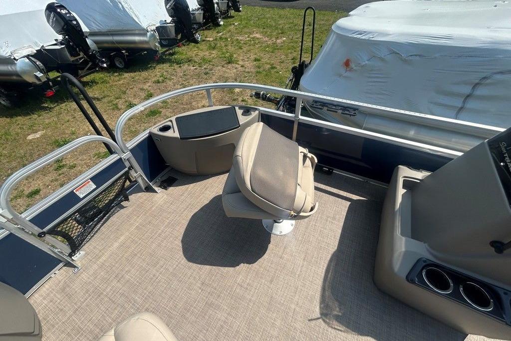 2023 Sun Tracker Bass Buggy 18 DLX interior with seating and console, parked outdoors.