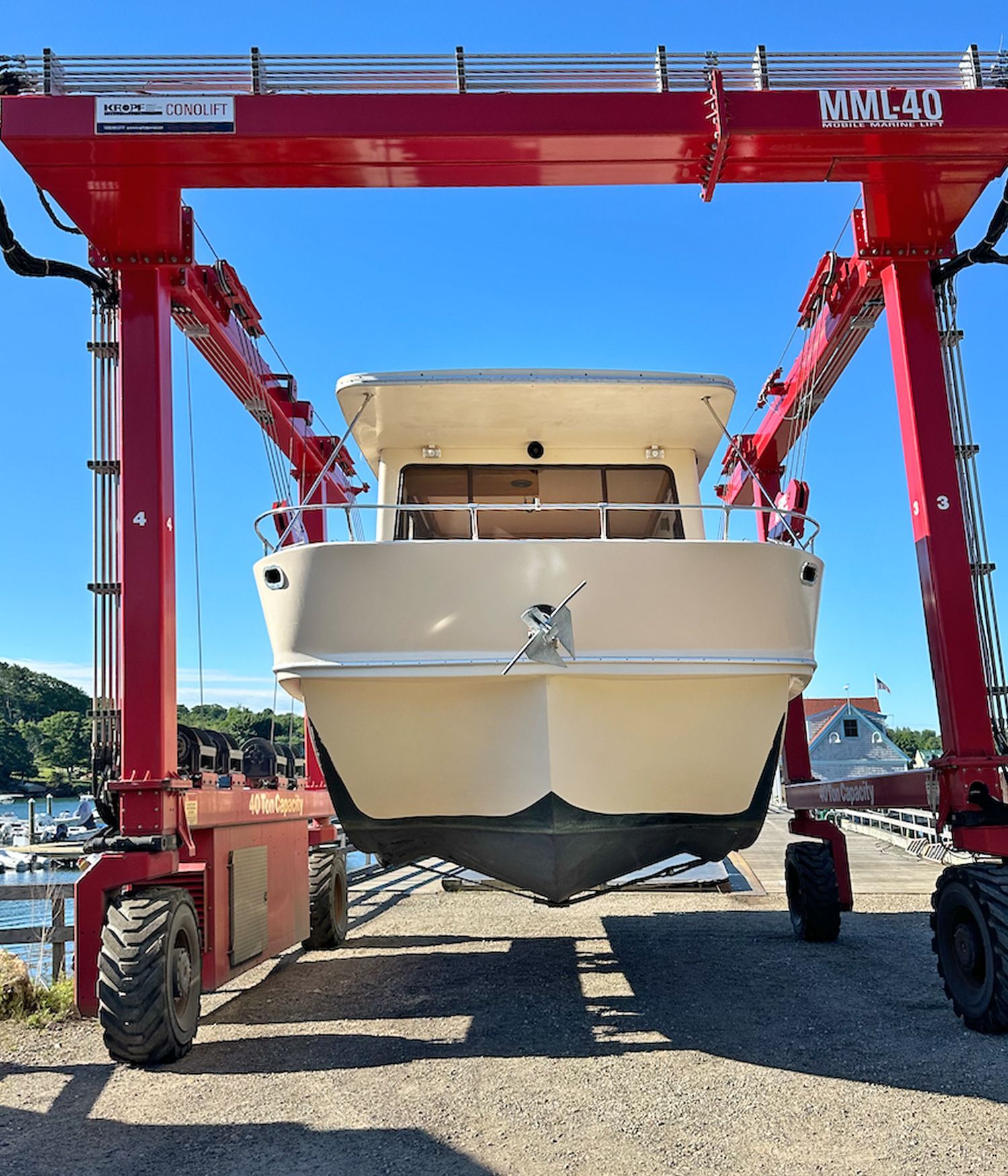 A 1988 Holiday Mansion Barracuda Coastal Cruiser being lifted out of the water by a large crane.