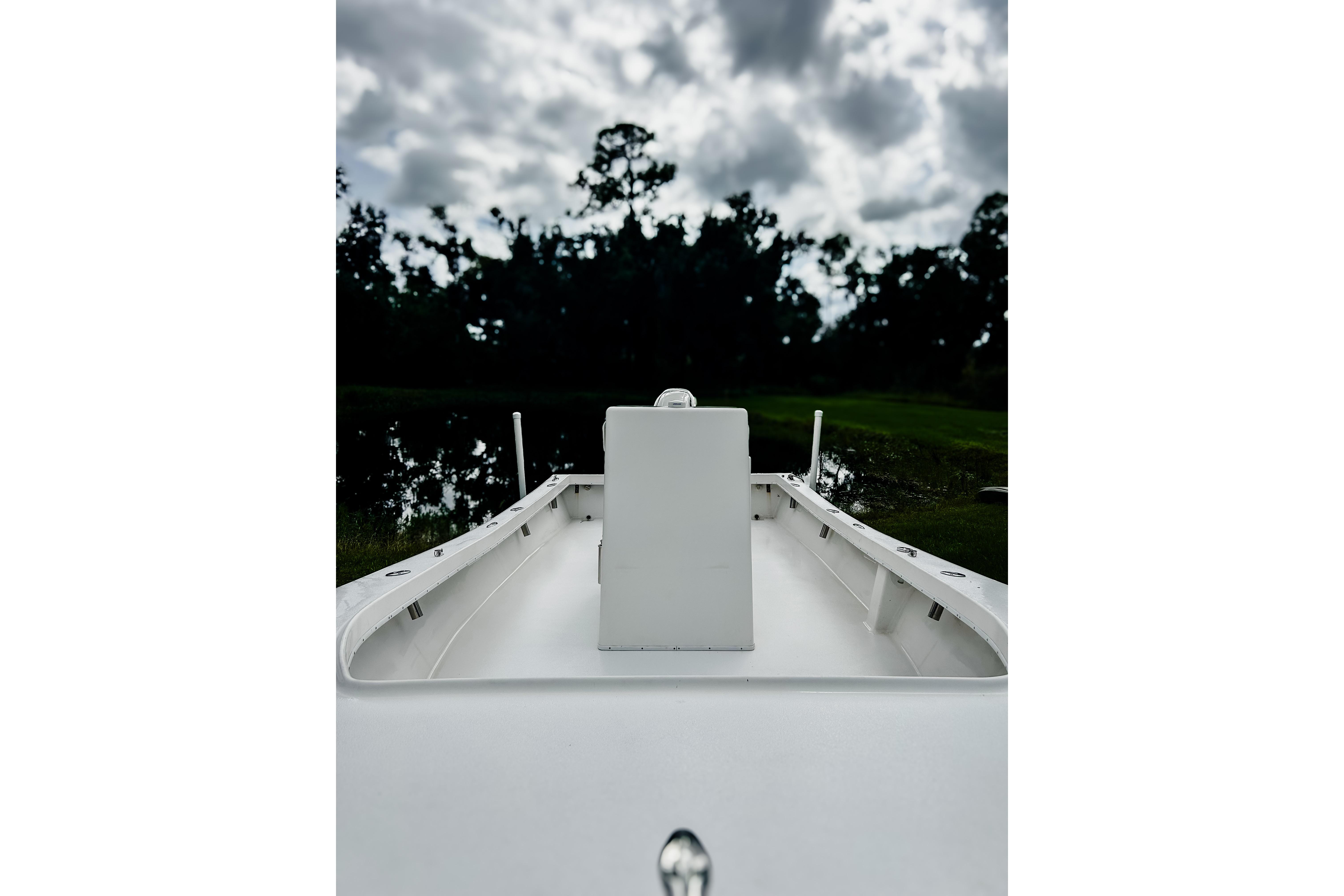 2024 Hanson 23 boat on calm water under cloudy sky.
