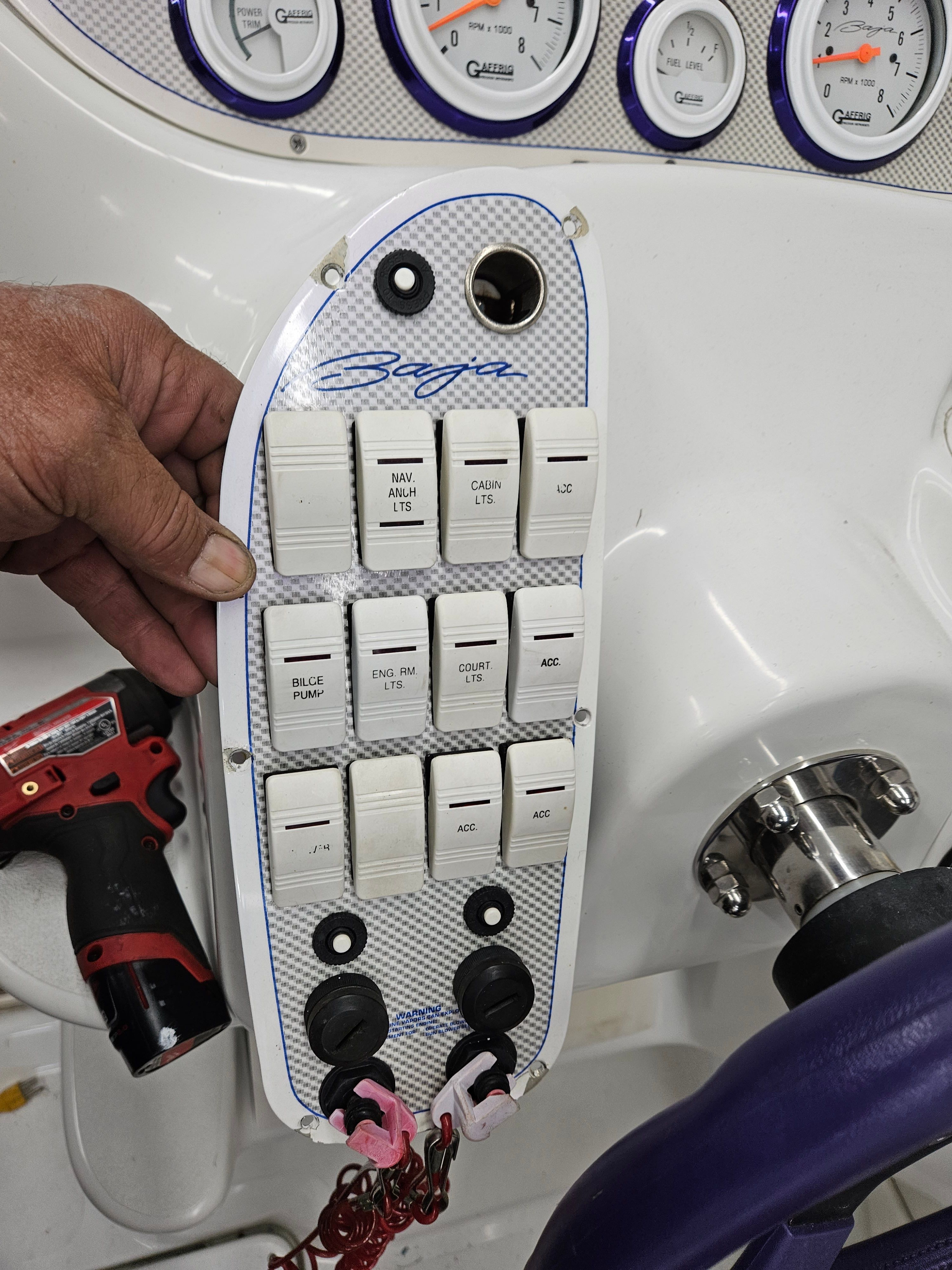 Close-up of a switch panel with toggle switches and sockets on a boat.