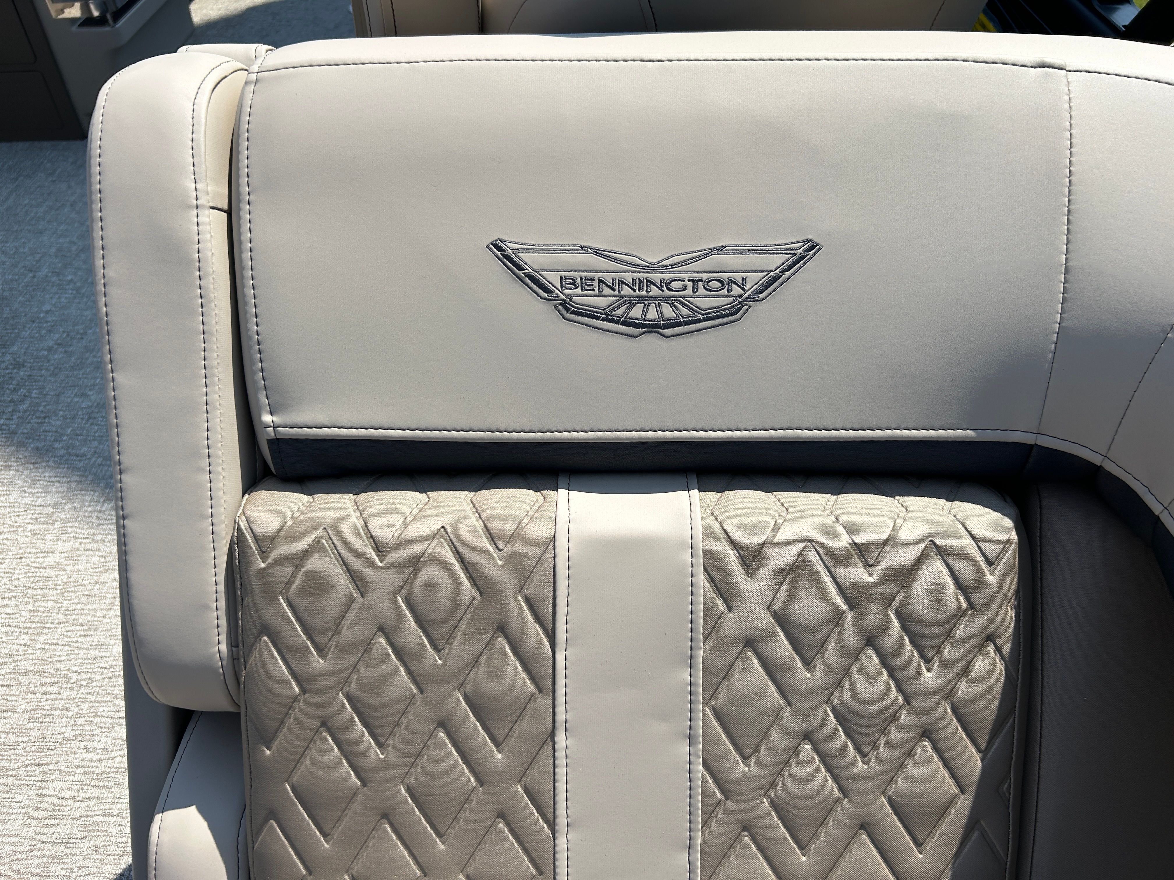 Close-up of a luxurious seat with quilted pattern and Bennington logo.
