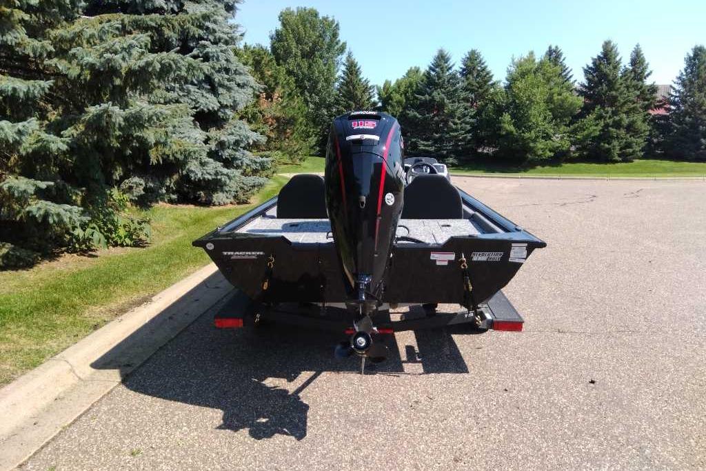2026 Tracker Pro Team 190 boat on trailer, parked near trees.