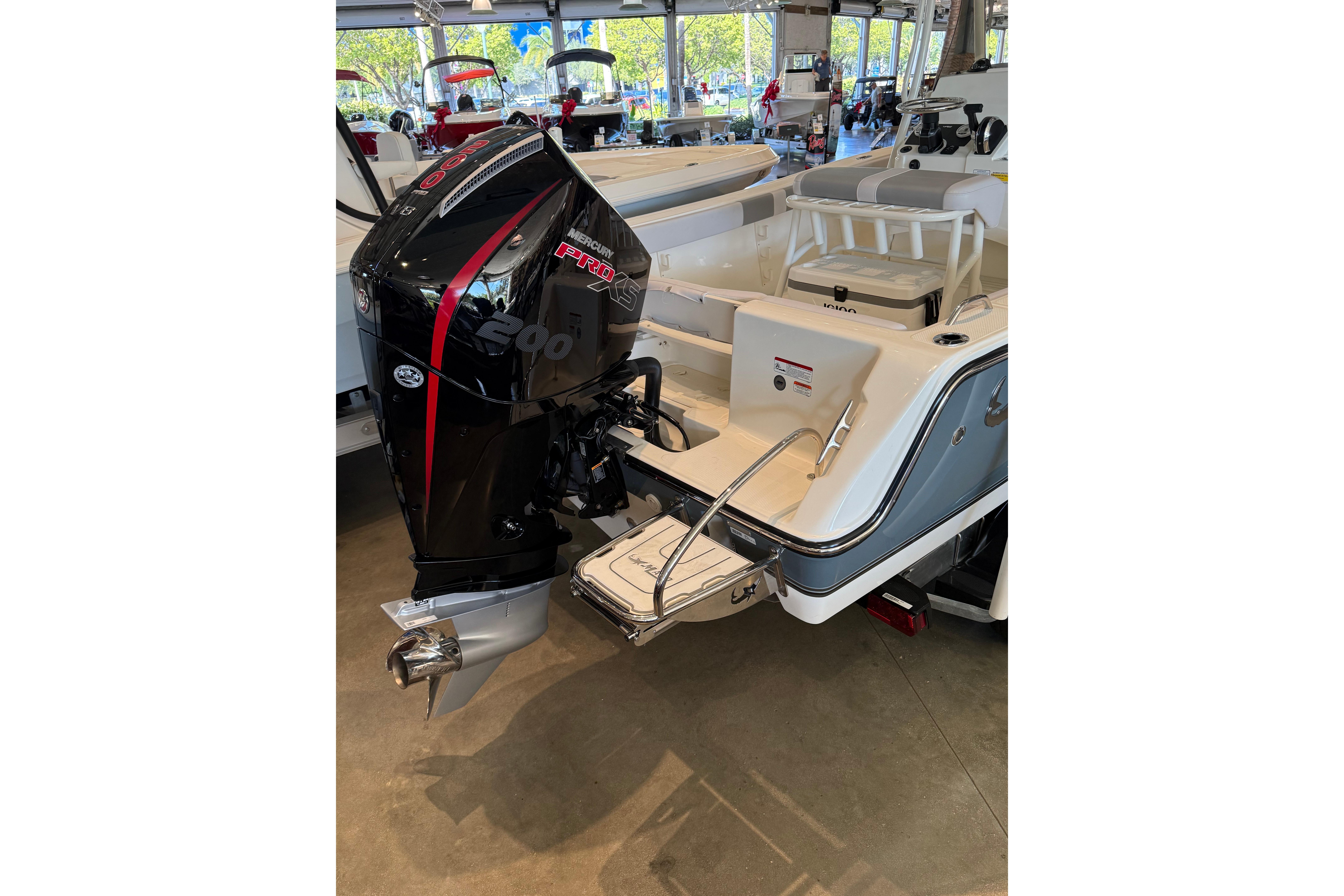2026 Mako 214 Center Console boat with Mercury Pro XS engine in showroom.