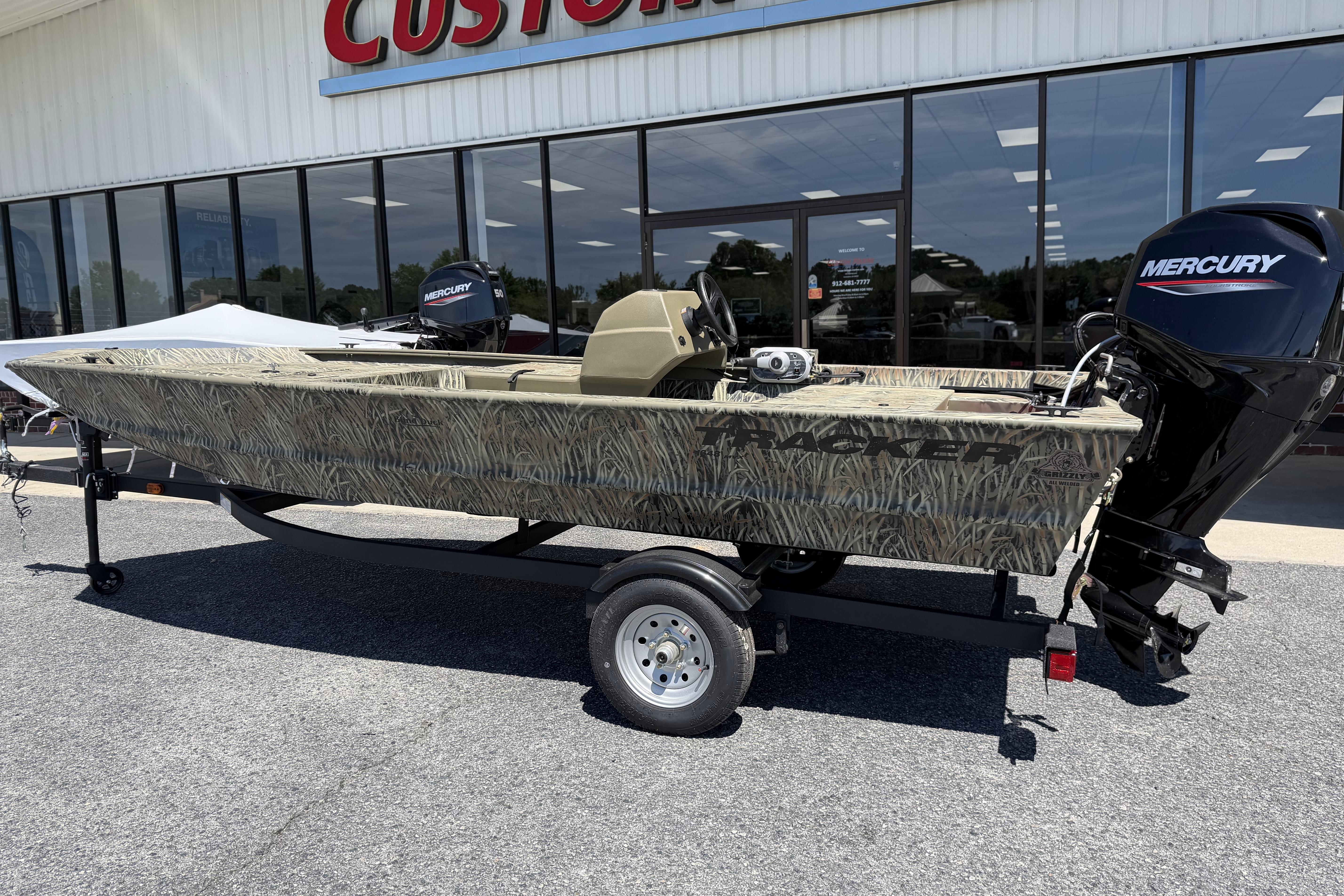 2026 Tracker Grizzly 1648 SC boat with camouflage design and Mercury outboard motor.