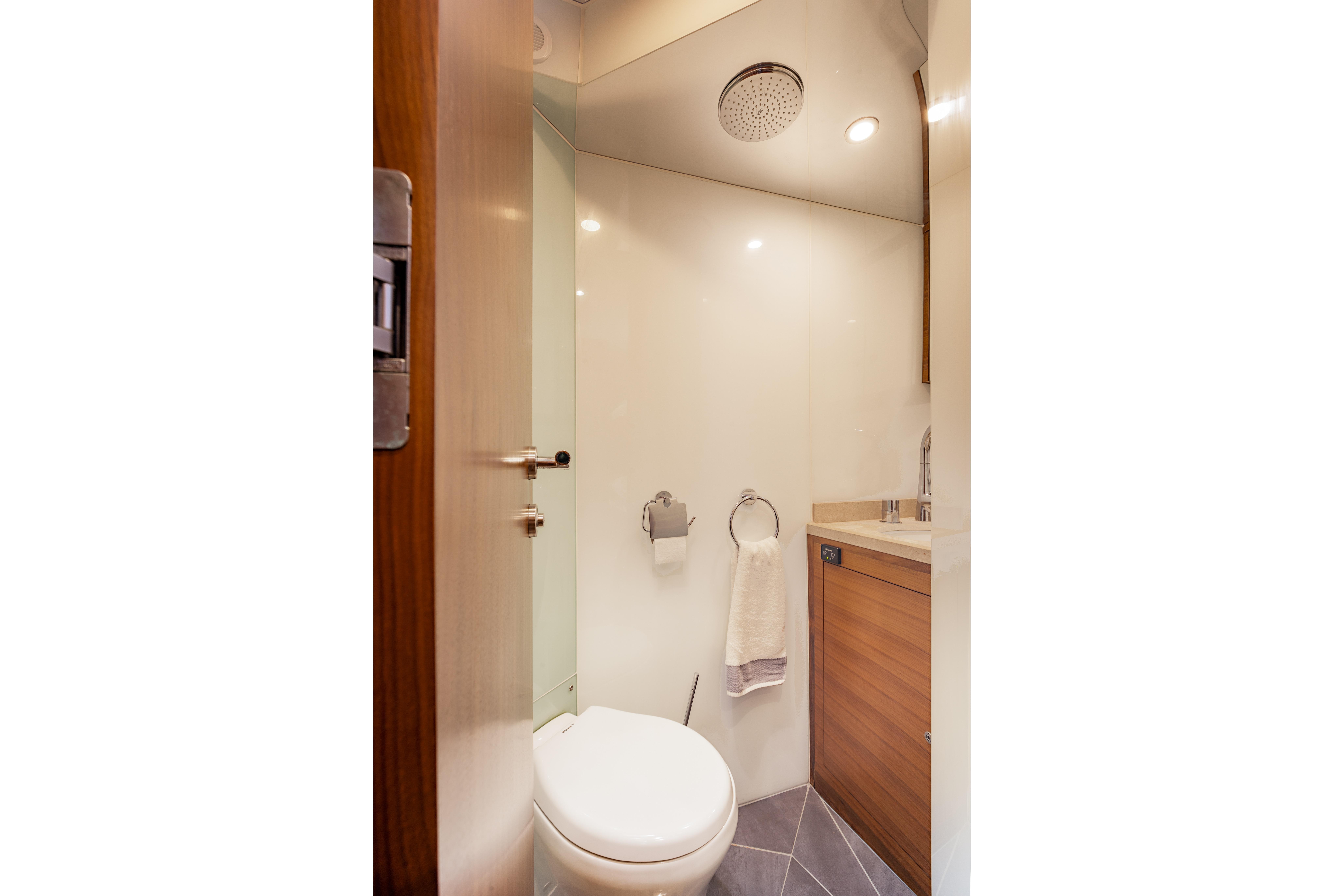 Luxurious bathroom in 2016 Outer Reef Trident 620 yacht, featuring modern fixtures and elegant wood accents.