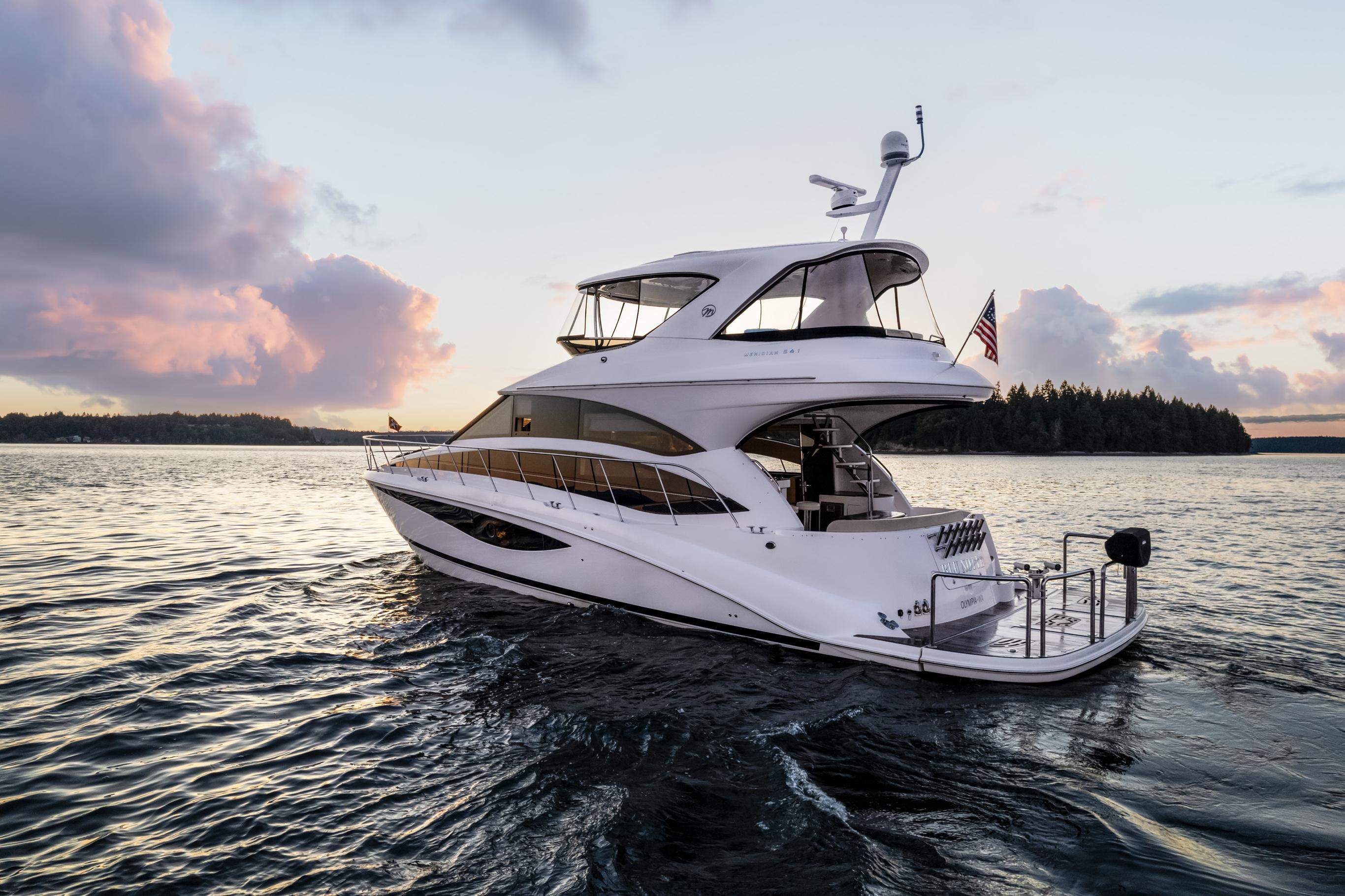 Luxurious 2012 Meridian 541 Sedan yacht cruising at sunset on serene waters.