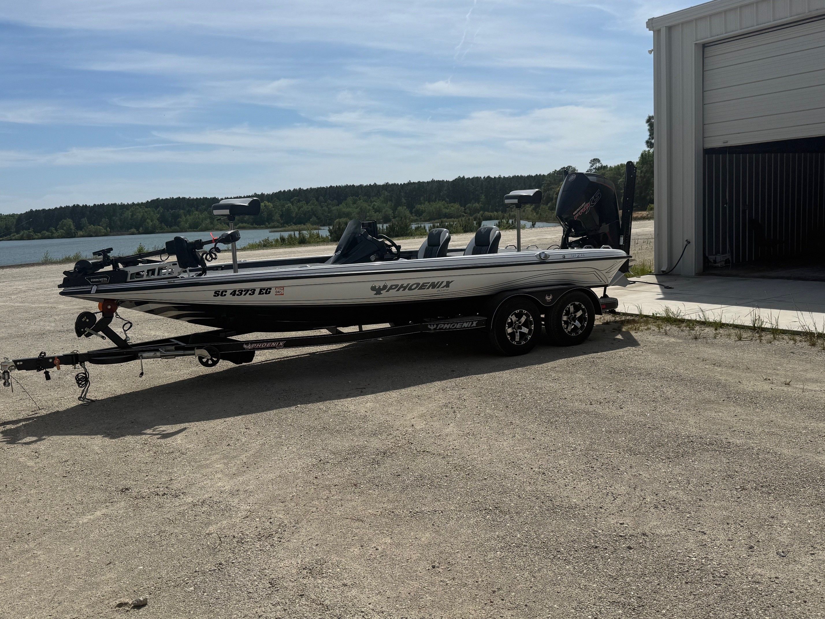 2025 Phoenix 721 ZXL boat on trailer beside storage building.