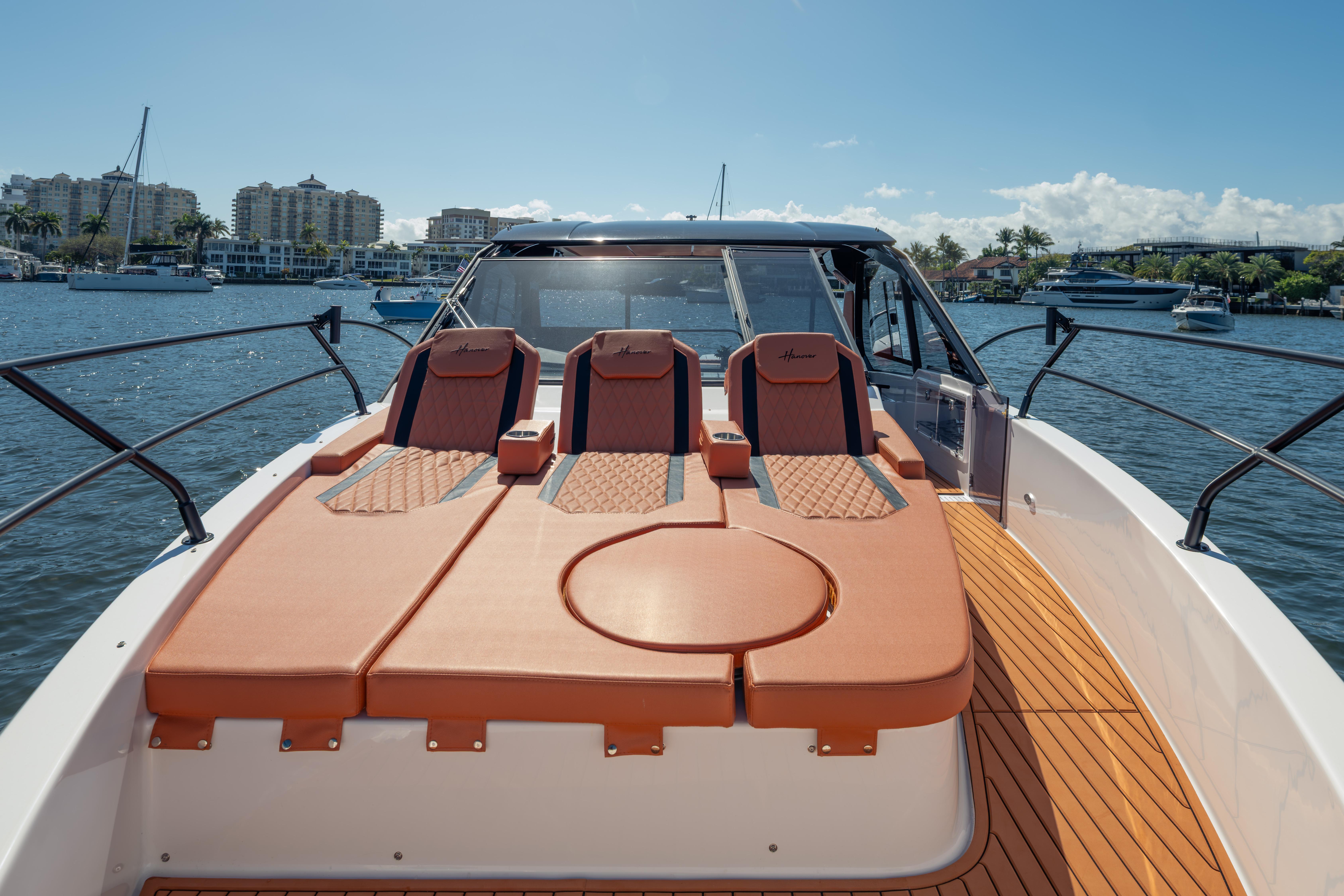 Luxurious 2026 Hanover 387 yacht with sun loungers, docked in a scenic marina.
