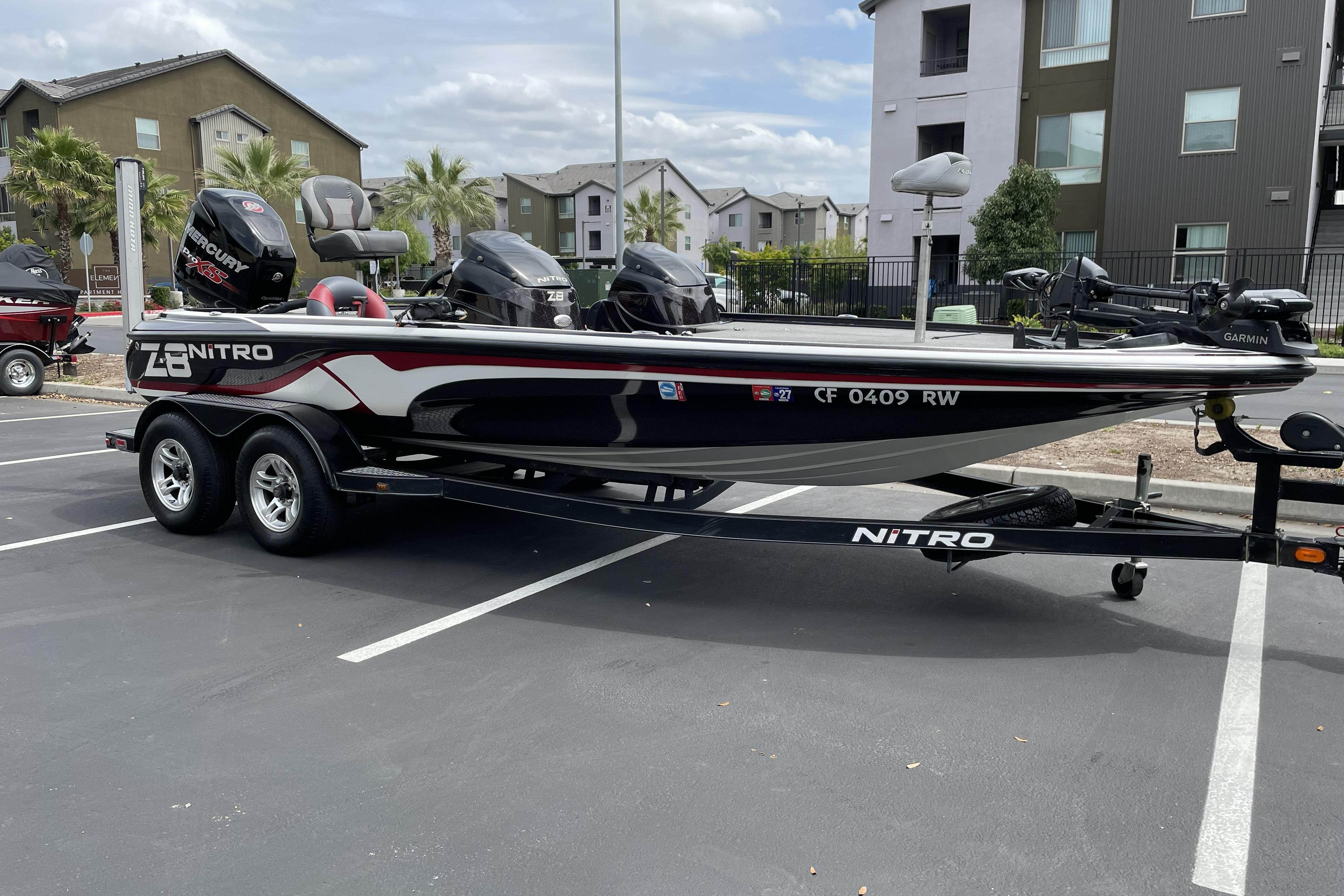 2013 Nitro Z-8 boat with Mercury engine on trailer in parking lot.