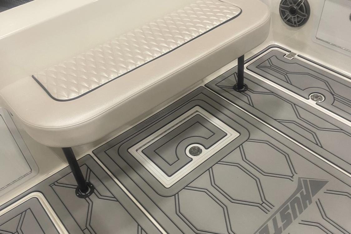 2025 Hustler 25 C3 Speedfish boat interior with cushioned seat and patterned flooring.