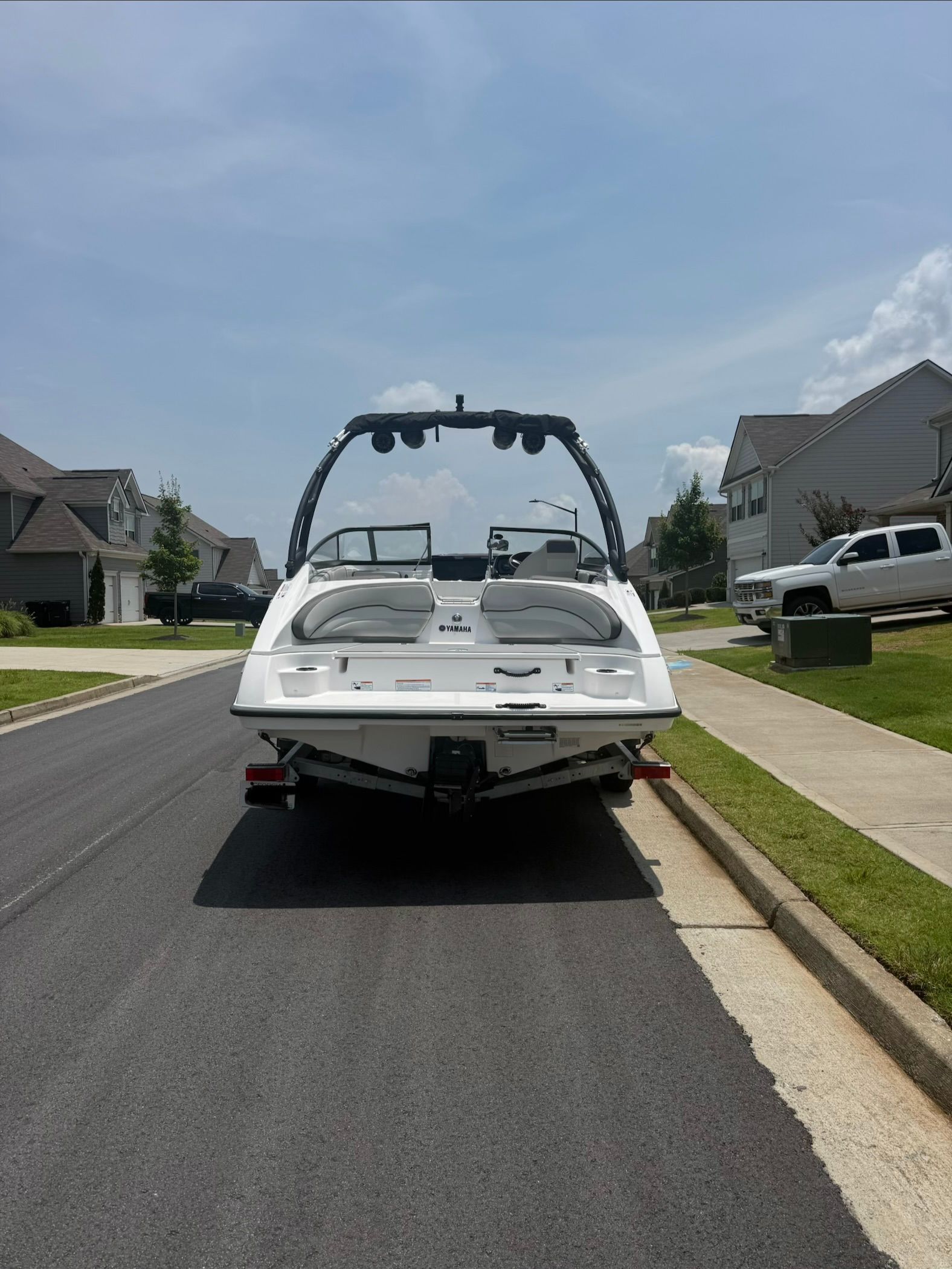 A 2023 Yamaha AR190 boat is parked on a street in a residential area.