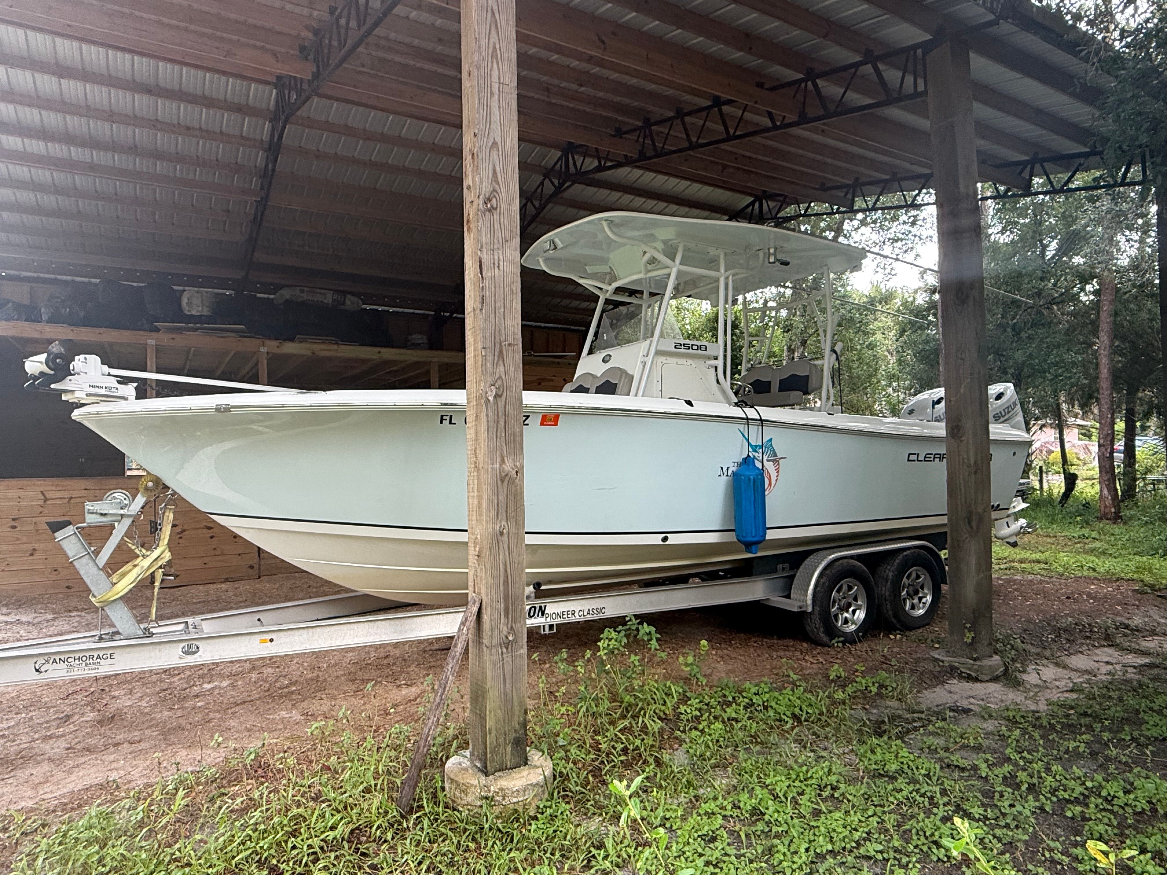 A 2021 Clearwater 2508 Center Console boat on a trailer under a covered area.