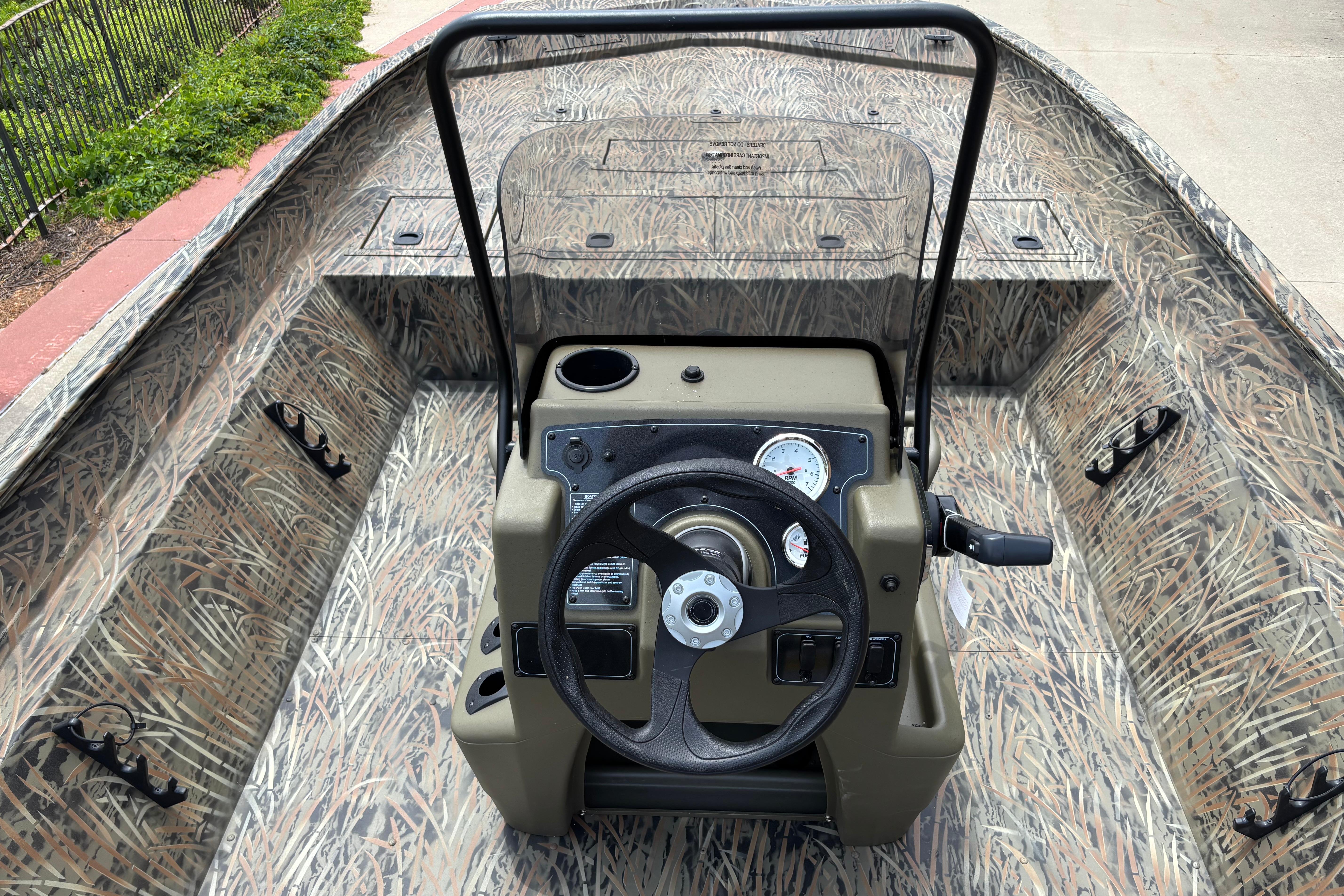 2026 Tracker Grizzly 2072 CC boat interior with camouflage design and steering console.