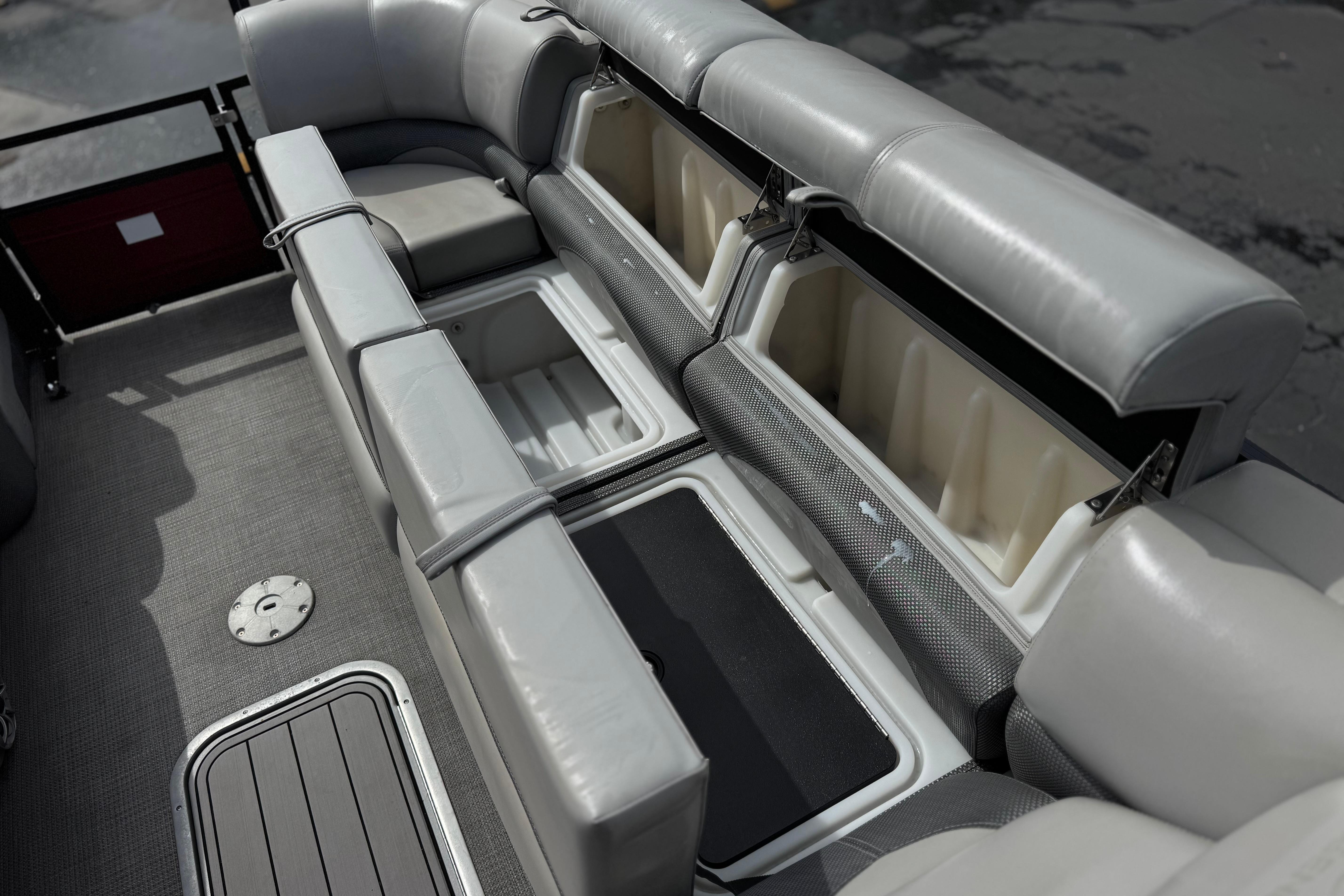 2022 Regency 250 DL3 boat interior with open storage compartments and gray seating.