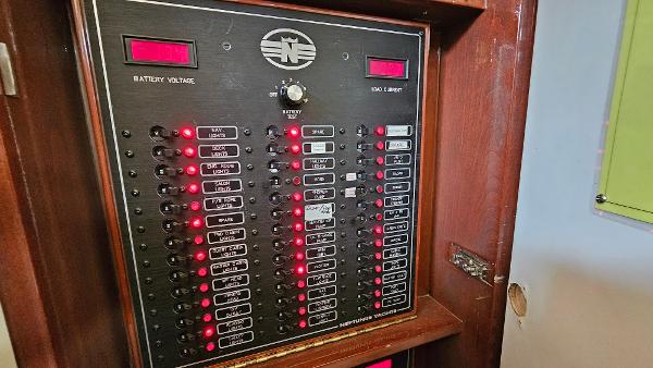 Electrical panel of 2005 Neptunus 56 Flybridge yacht with illuminated switches and indicators.