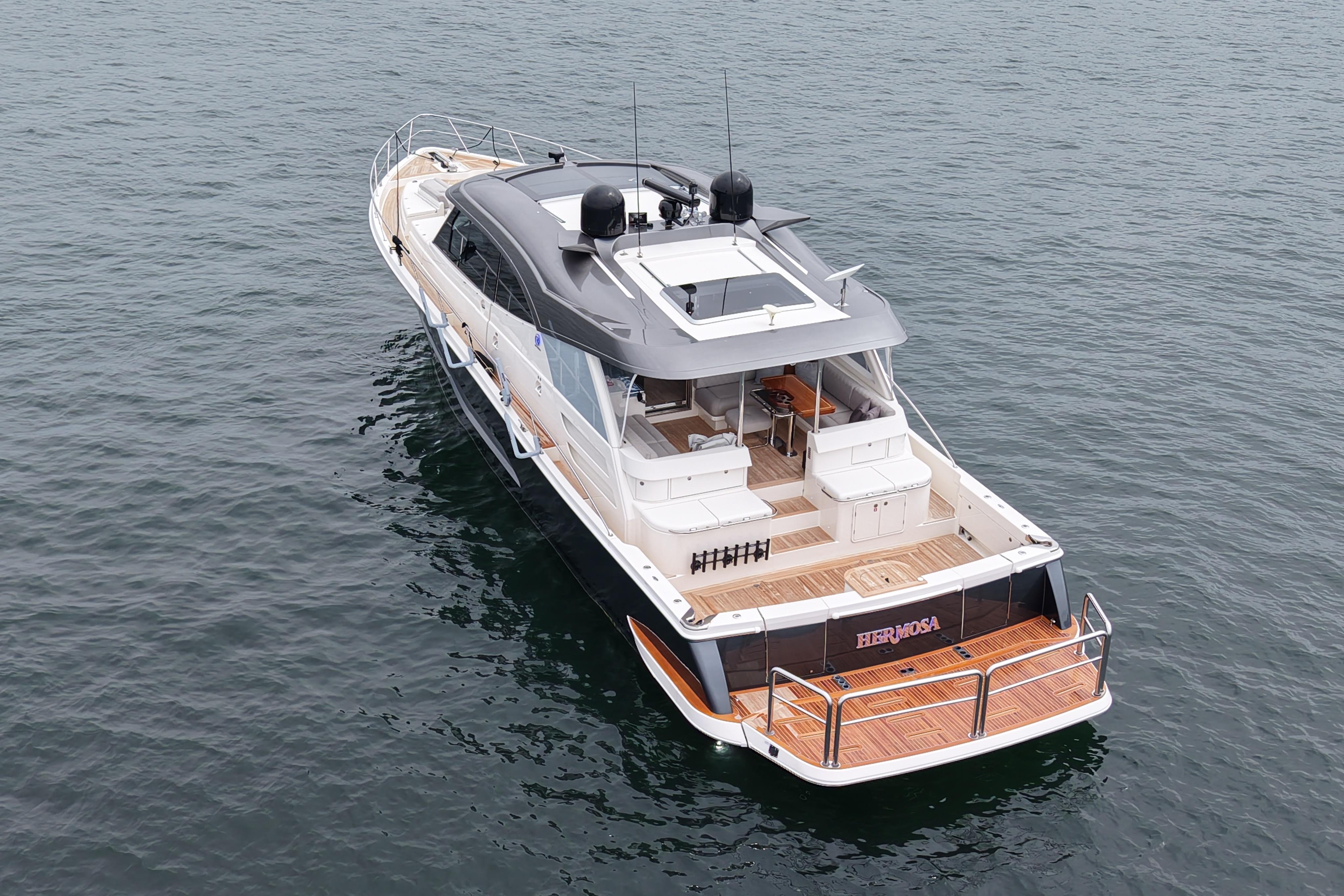 2023 Riviera 645 SUV yacht on calm water, showcasing sleek design and spacious deck.