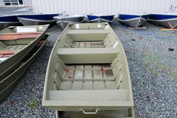 2024 Crestliner 1436L CR Jon boat on gravel lot, surrounded by other boats.