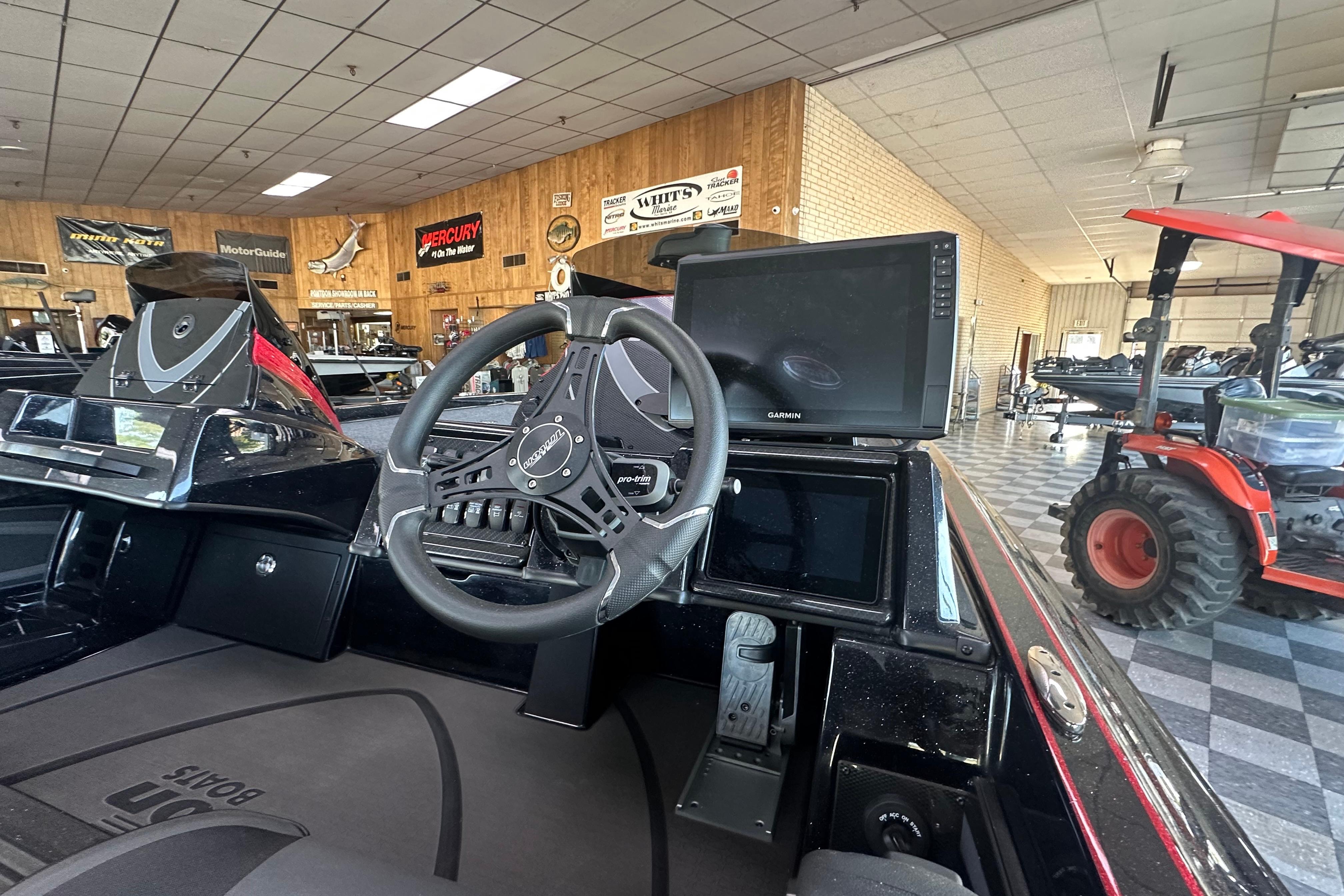 Interior of 2026 Triton 20XP Patriot boat with steering wheel and Garmin display.