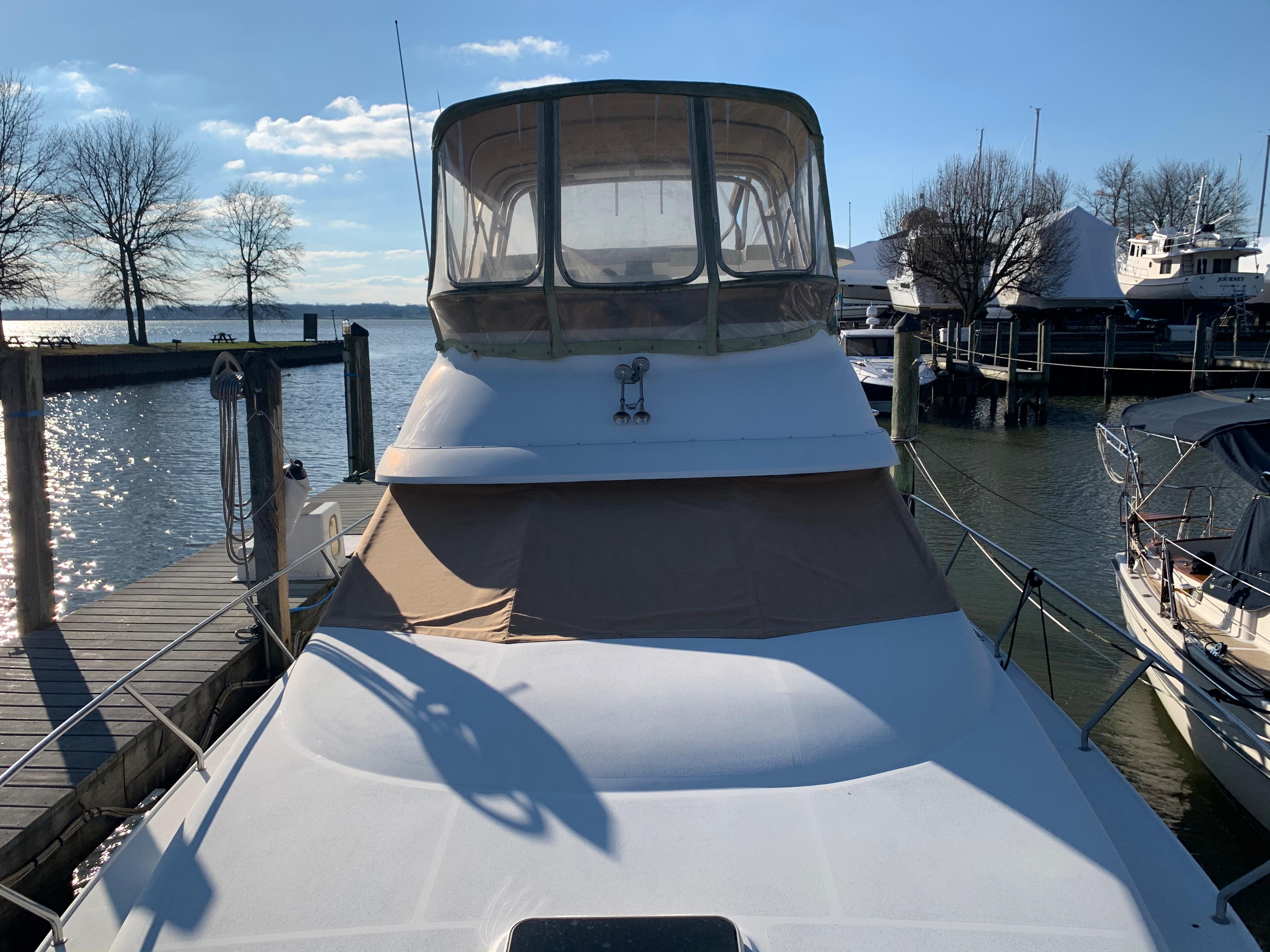 1992 Silverton 34 Aft Cabin Motor Yacht docked at marina under clear sky.