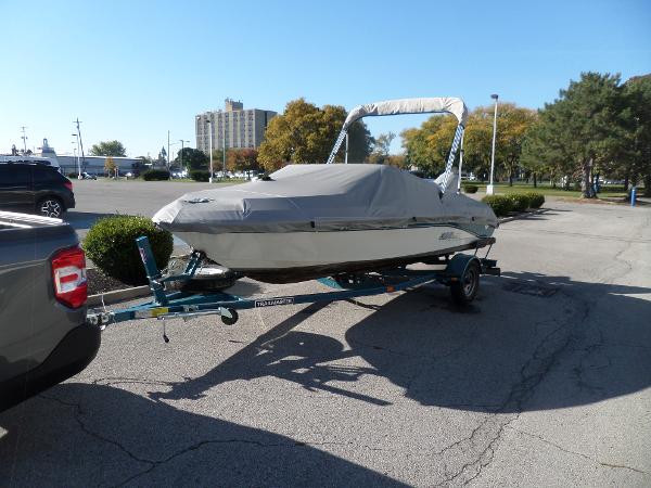 1992 Rinker Captiva 170 OB boat on trailer, covered, parked in a lot.