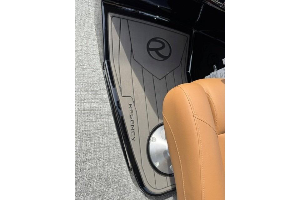 2026 Regency 230 DL boat interior with tan leather seat and branded flooring.