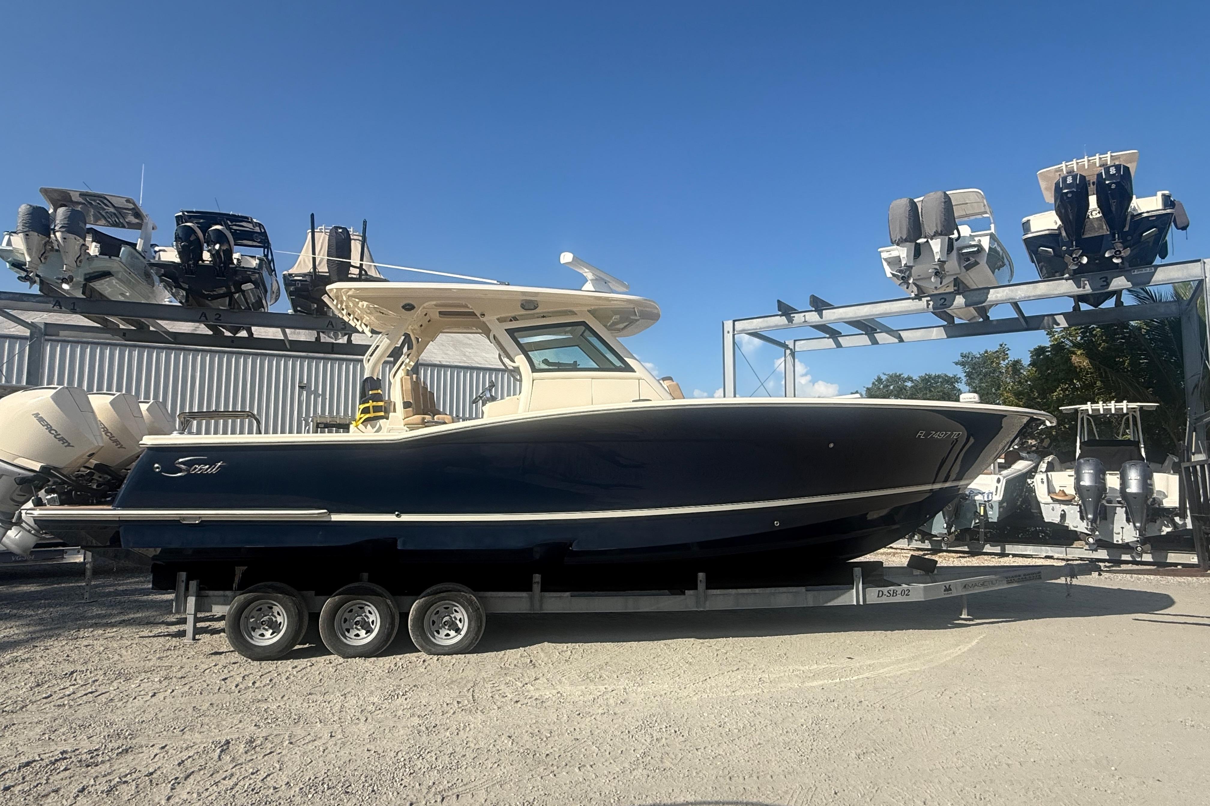 2022 Scout 355 LXF boat on trailer, displayed outdoors under clear blue sky.