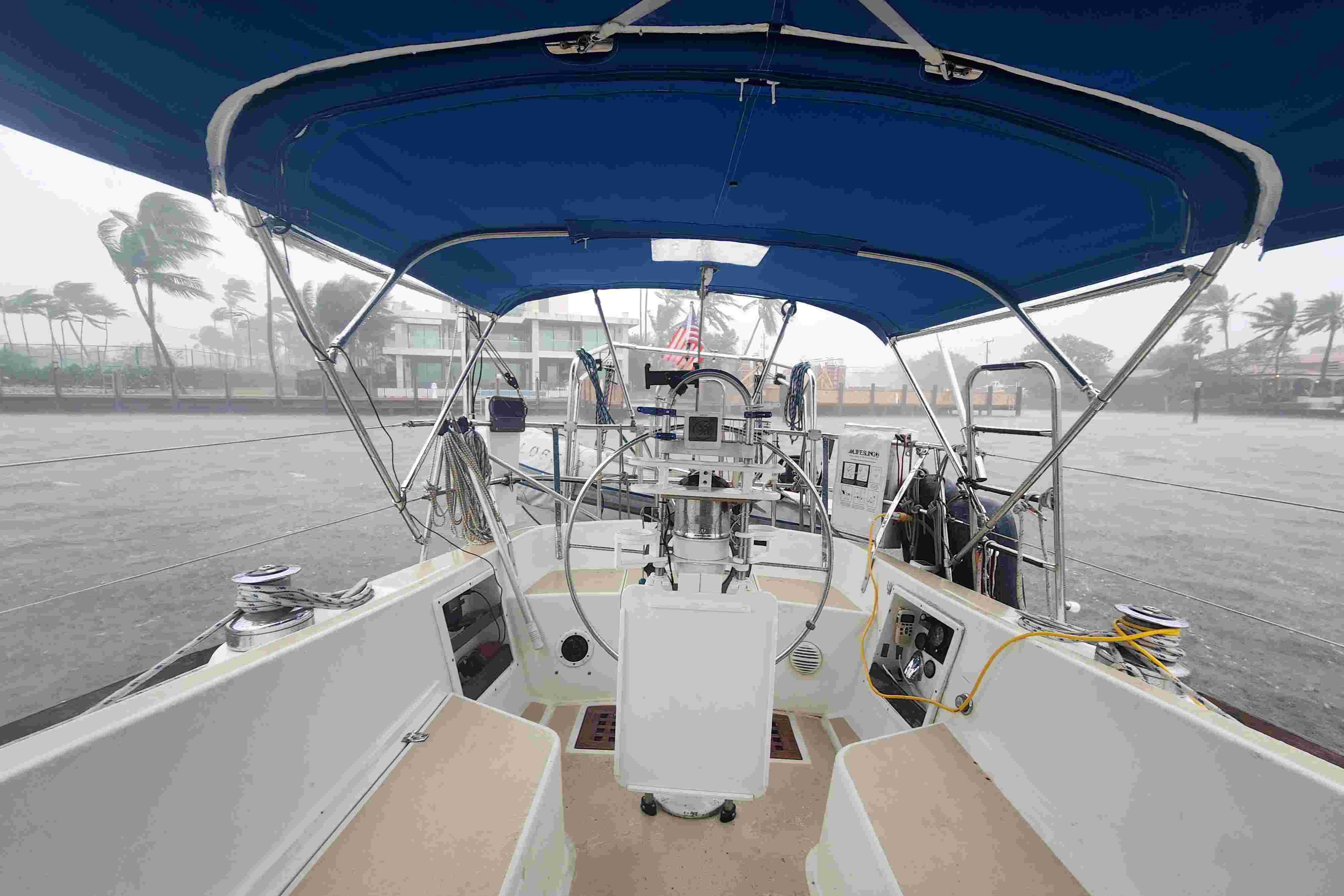 Cockpit view of 1979 Tartan T 37 sailboat with blue canopy in stormy weather.