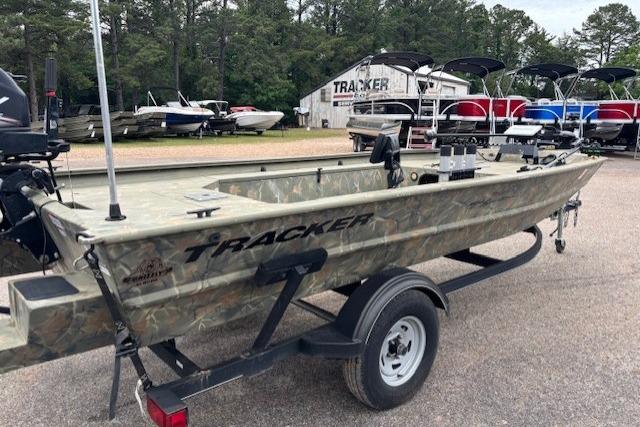2017 Tracker Grizzly 1654 MVX Sportsman boat on trailer, parked outdoors near other boats.